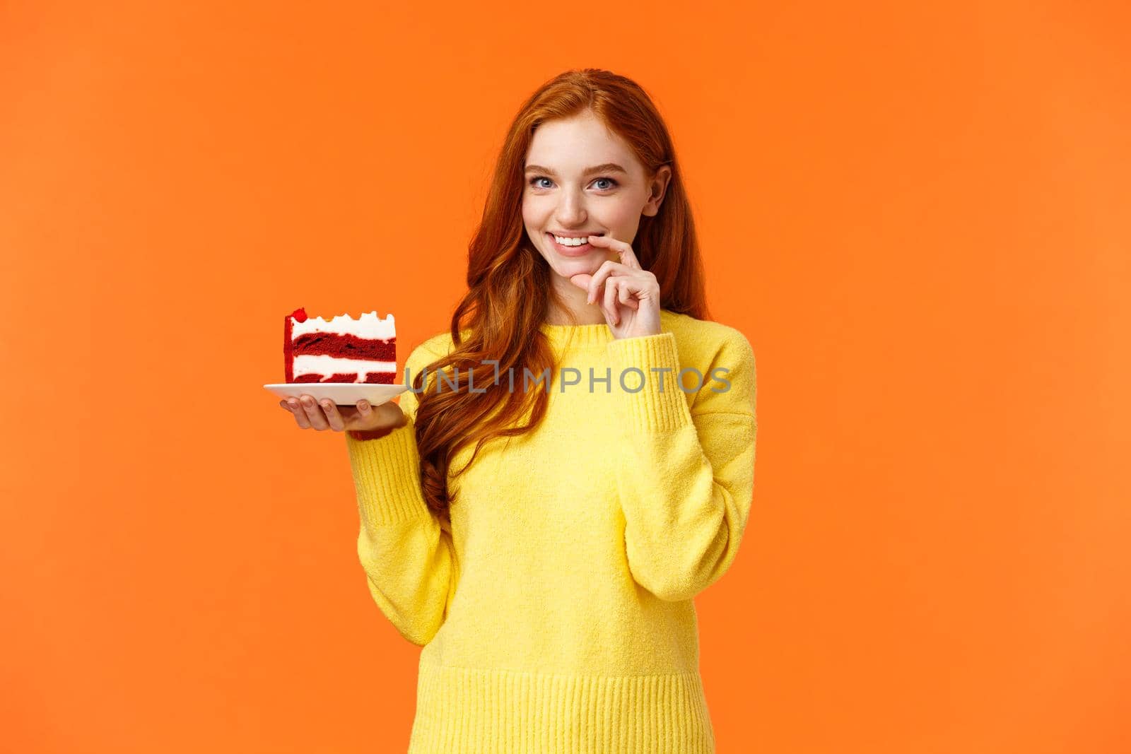 Girl wants share her piece cake with loved one. Romantic silly cute girlfriend brink piece dessert to eat together, smiling and touching lip flirty, eating junk food during diet, orange background.
