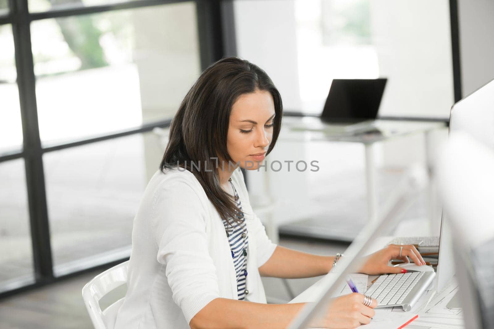 Attractive brunette woman at office desk work on computer