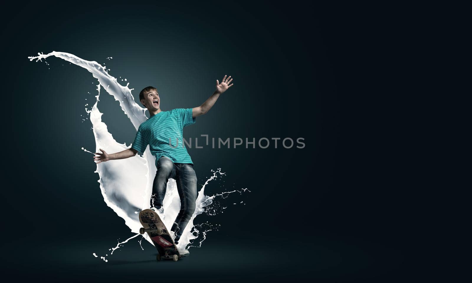 Young guy riding skateboard and paint splashes from under wheels