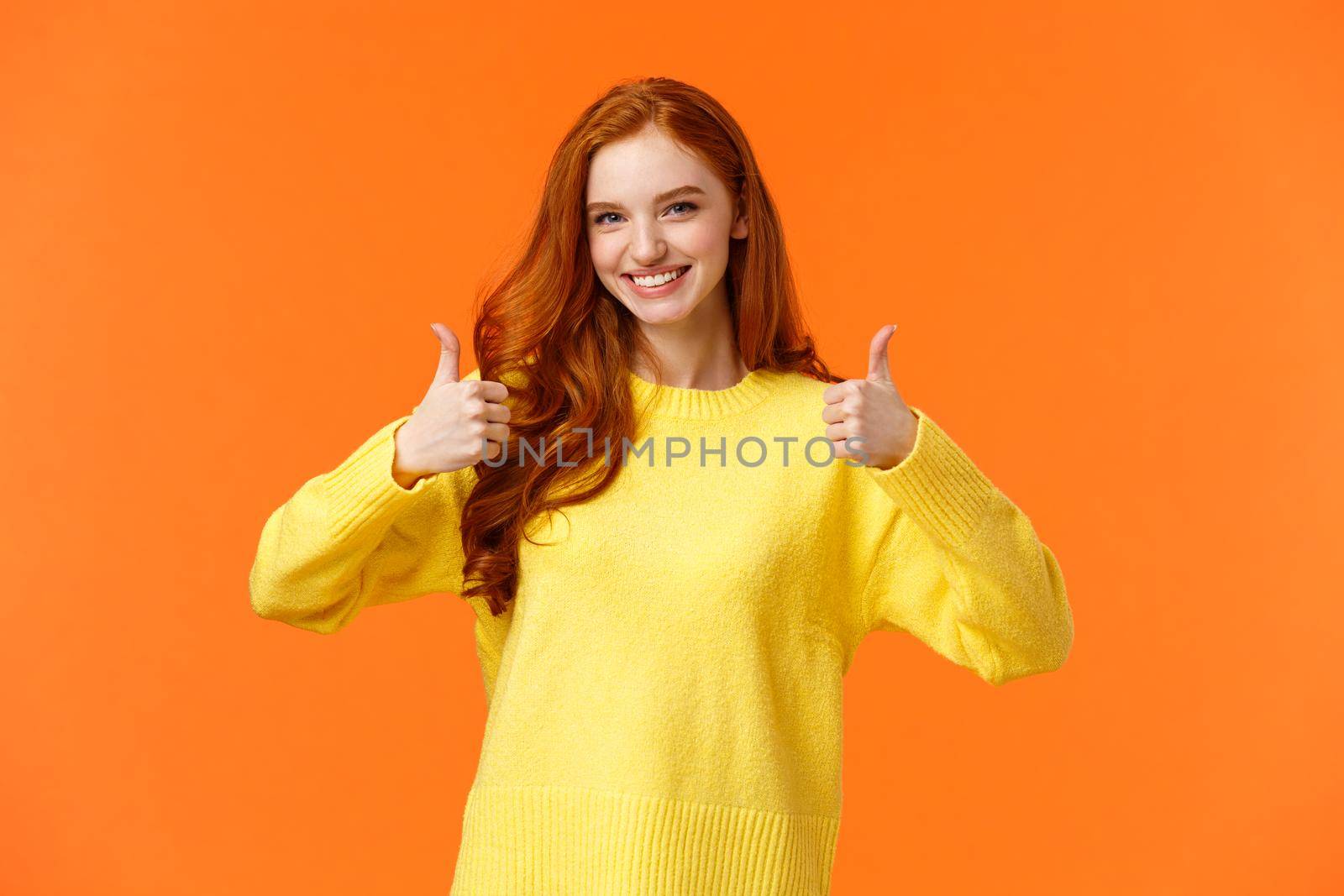 Confident and caring good-looking redhead sister rooting for sibling, saying yes, approving choice, recommend product, show thumbs-up and nod acceptance, smiling positive reply, orange wall by Benzoix