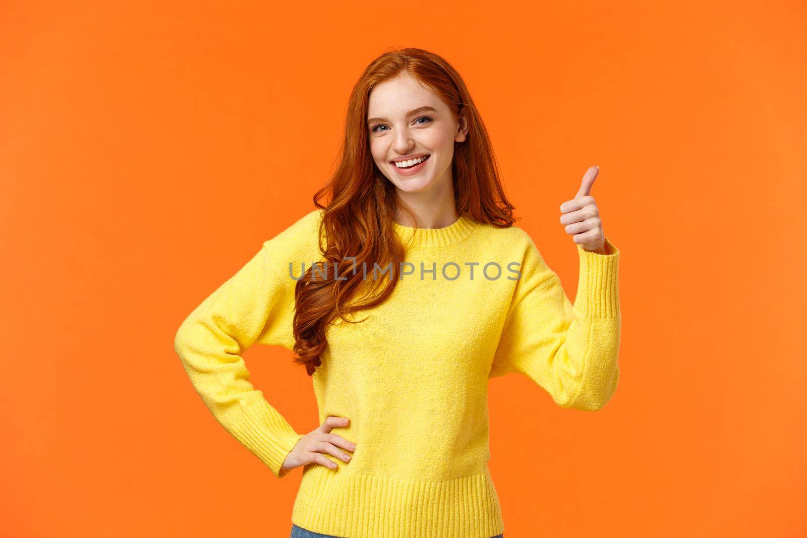 Sounds good, count me in. Waist-up shot cheerful upbeat girl make thumb-up gesture and smiling in approval, like idea, recommend consumer nice product, standing orange background. Copy space