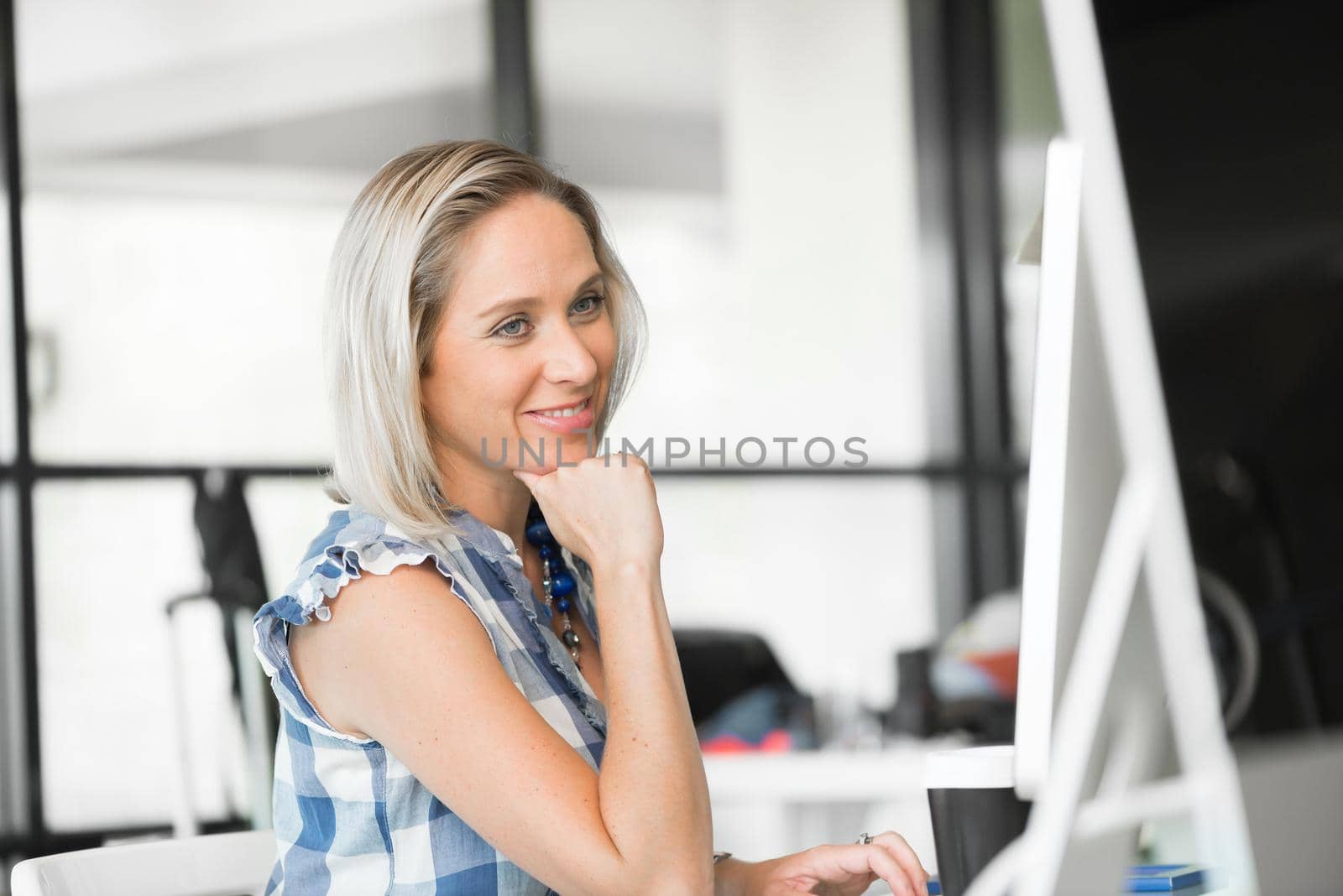 Attractive woman sitting at desk in modern office