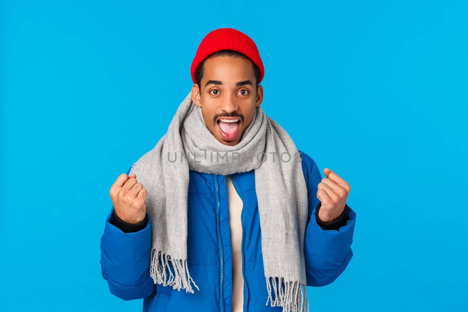 Yeah we can do it. Encouraged and motivated good-looking cheerful african american man in padded jacket, scarf winter beanie, clench arms triumphing, getting ready, boost confidence by Benzoix