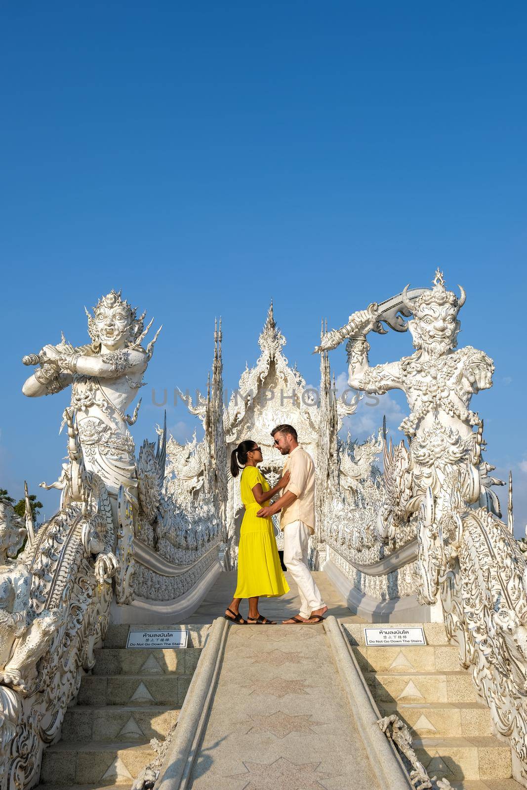 Chiang Rai Thailand, white temple Chiangrai during sunset, Wat Rong Khun, aka The White Temple, in Chiang Rai, Thailand. Panorama white temple Thailand, couple man and woman visit temple