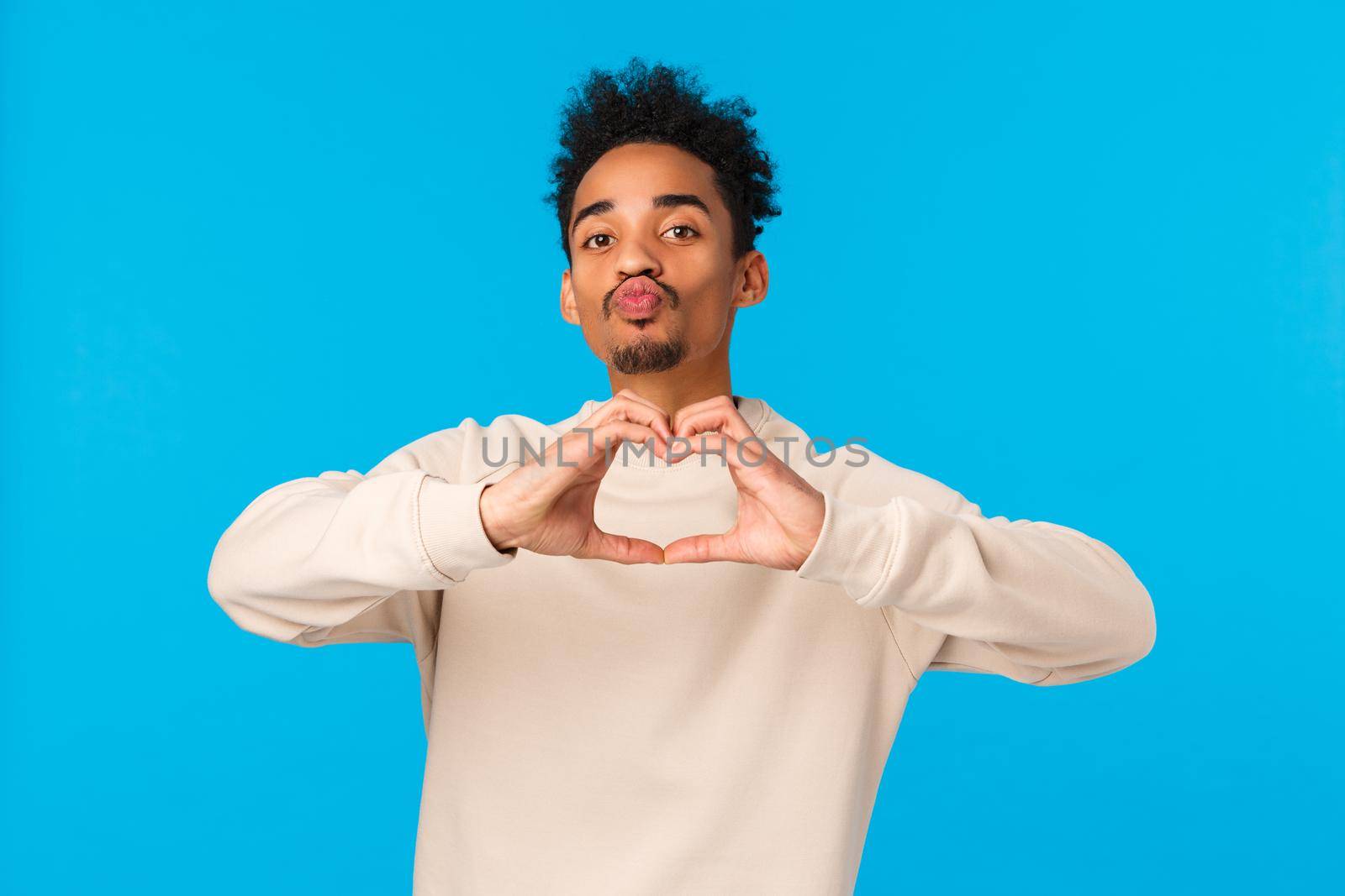 Relationship, romance and feelings concept. Man decided give himself as present for valentines day. Cheeky cute african american boyfriend showing heart sign with love and folding lips to kiss.