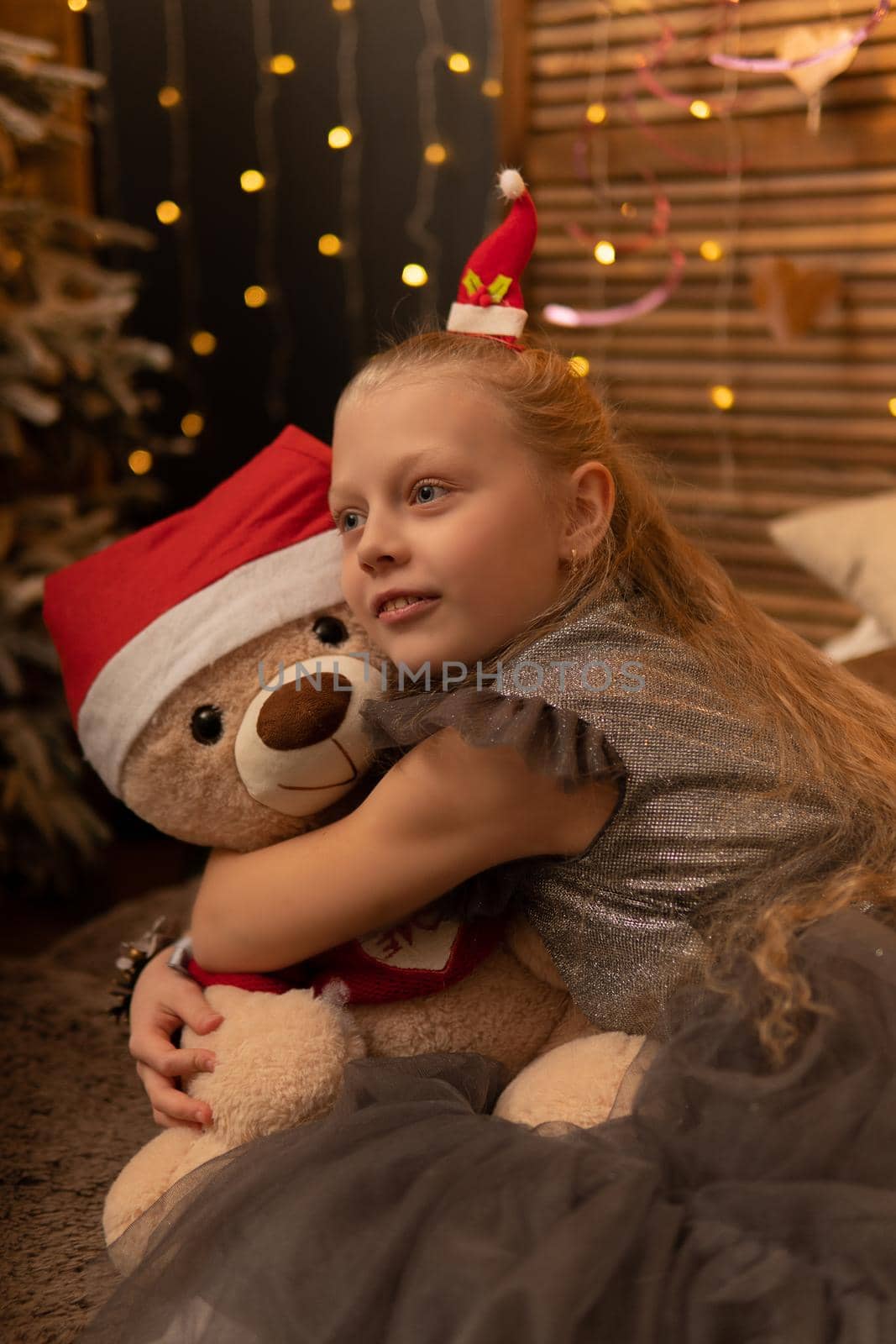 A girl hugs a bear toy in a Christmas cap bear Christmas kid girl happy, for female smiling from teddy white fun, joy baby. Gift bed holding, hug wake by 89167702191