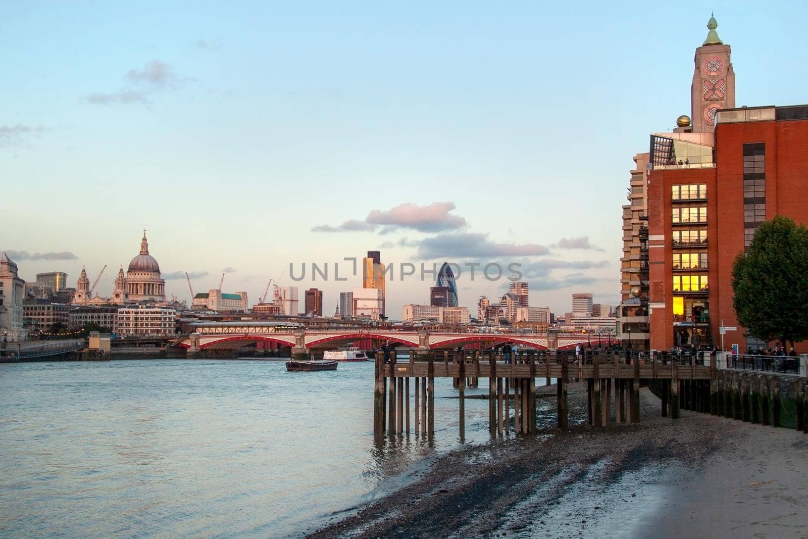 London, United Kingdom - October 7th, 2006:  Thames Riverside in the evening, Blackfriars Bridge and St. Paul Cathedral in the background, people enjoying warm autumn afternoon under OXO tower.