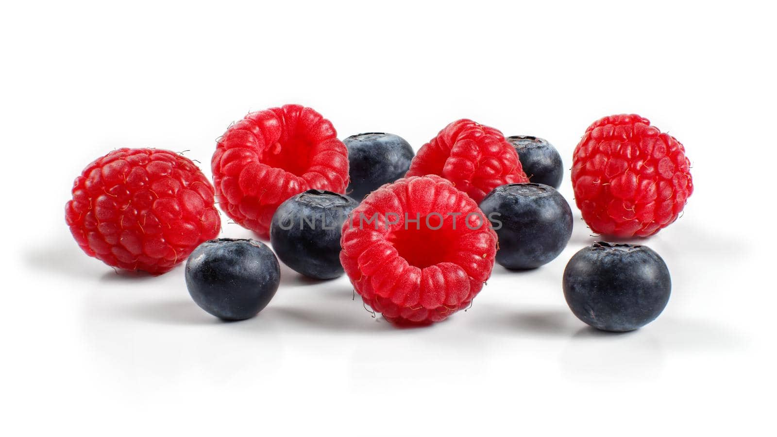 Mixed blueberries and raspberries isolated on white background