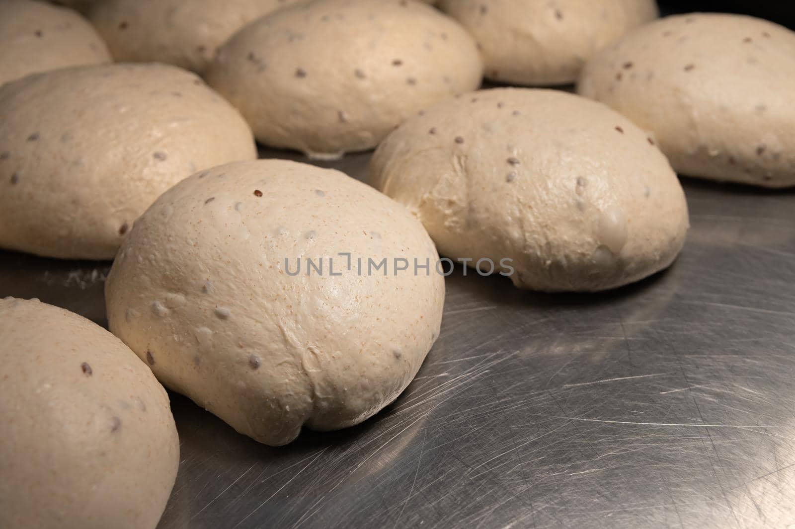 Close-up Homemade yeast dough buns for cutlets on a baking sheet. Hamburger buns dough pieces by yanik88