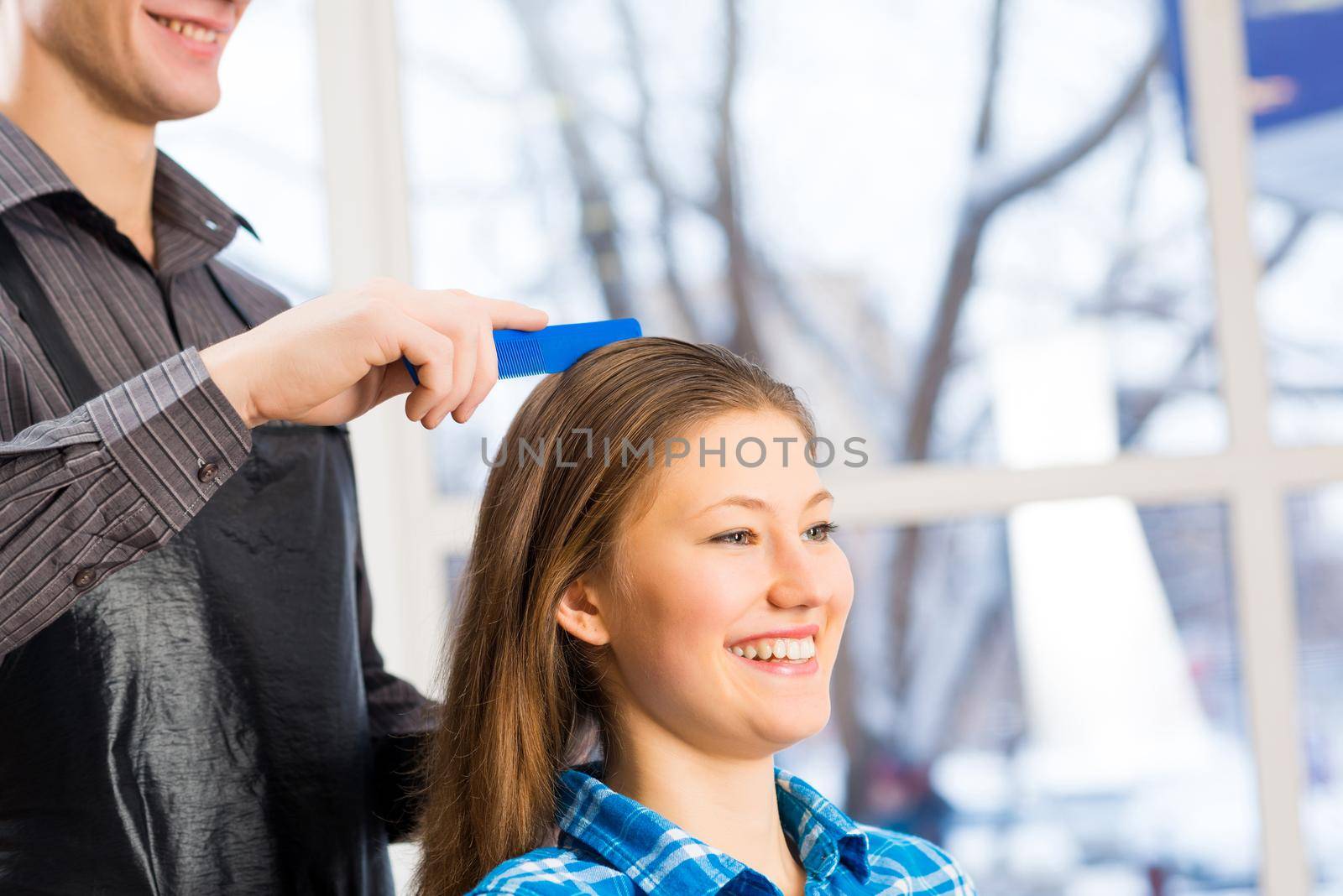 male hairdresser puts woman&#39;s hair in a hairdressing salon