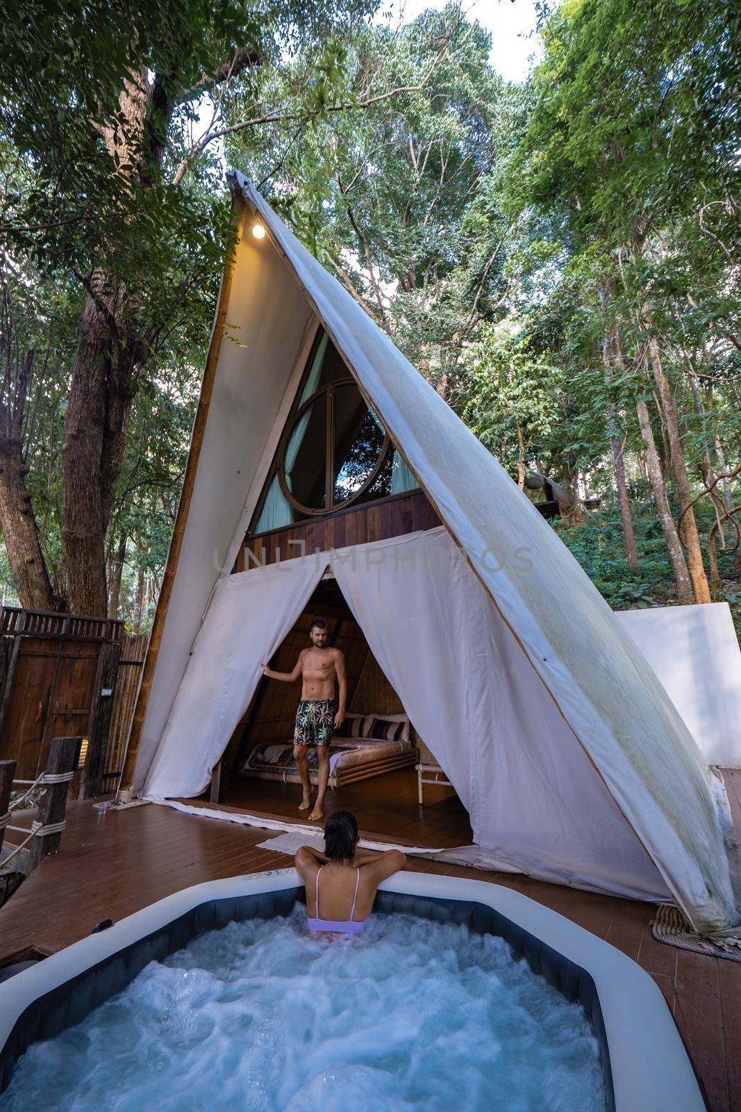 Glamping in Northern Thailand, couple man and woman in tent with jaccuzzi , man and woman in bungalow in the mountains of Thailand by fokkebok