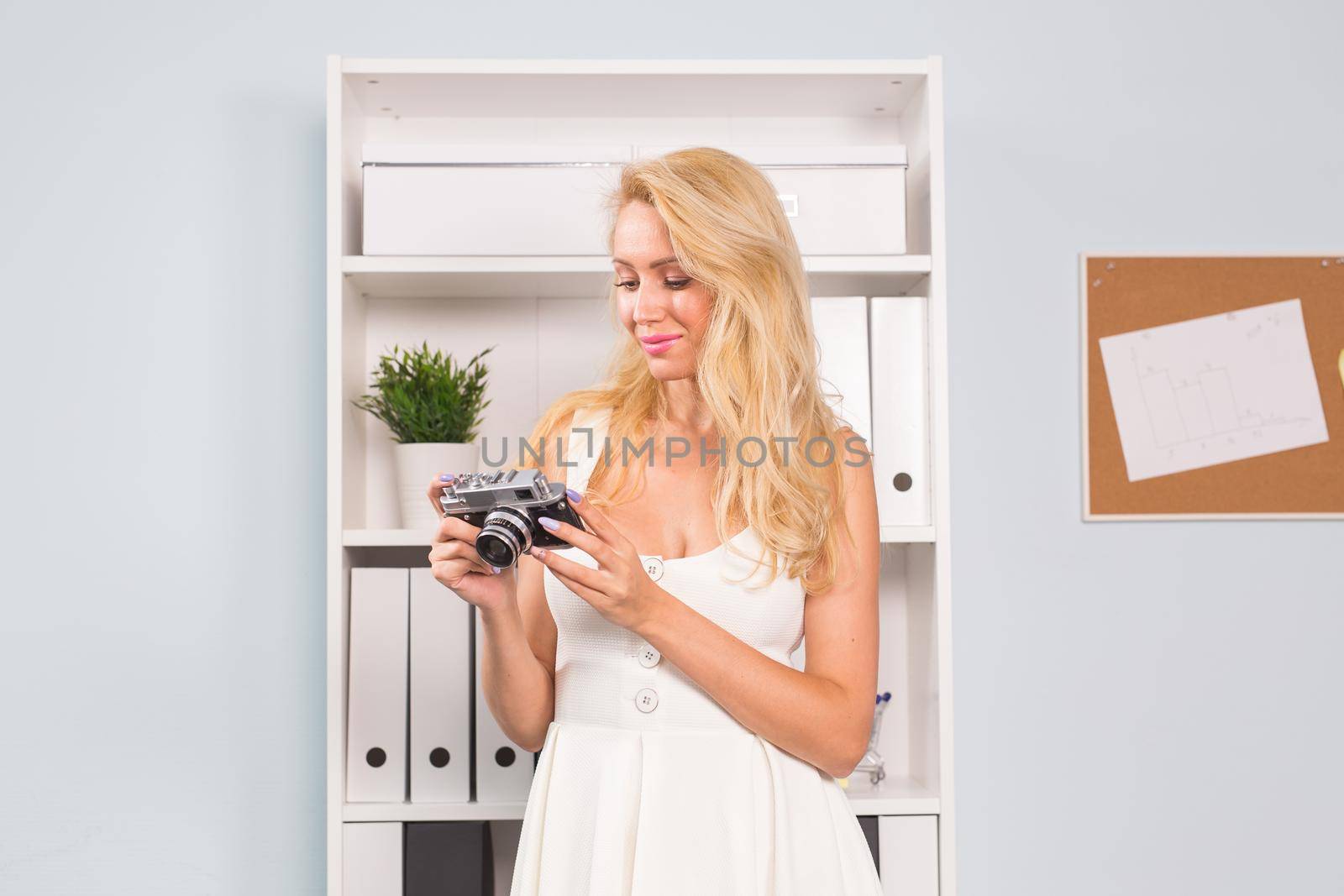 Hobby and people concept - Close up portrait of beautiful woman in white dress holding vintage photo camera.