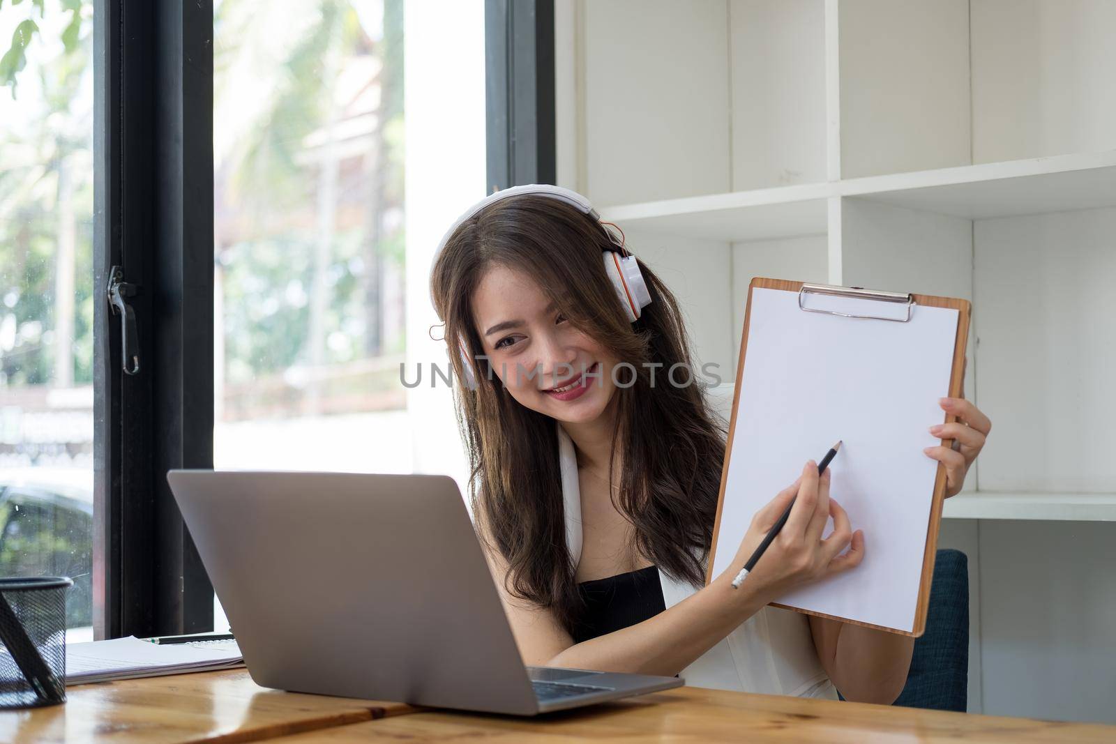 Asian woman teacher giving online lessons, Girl having video call on laptop computer at home