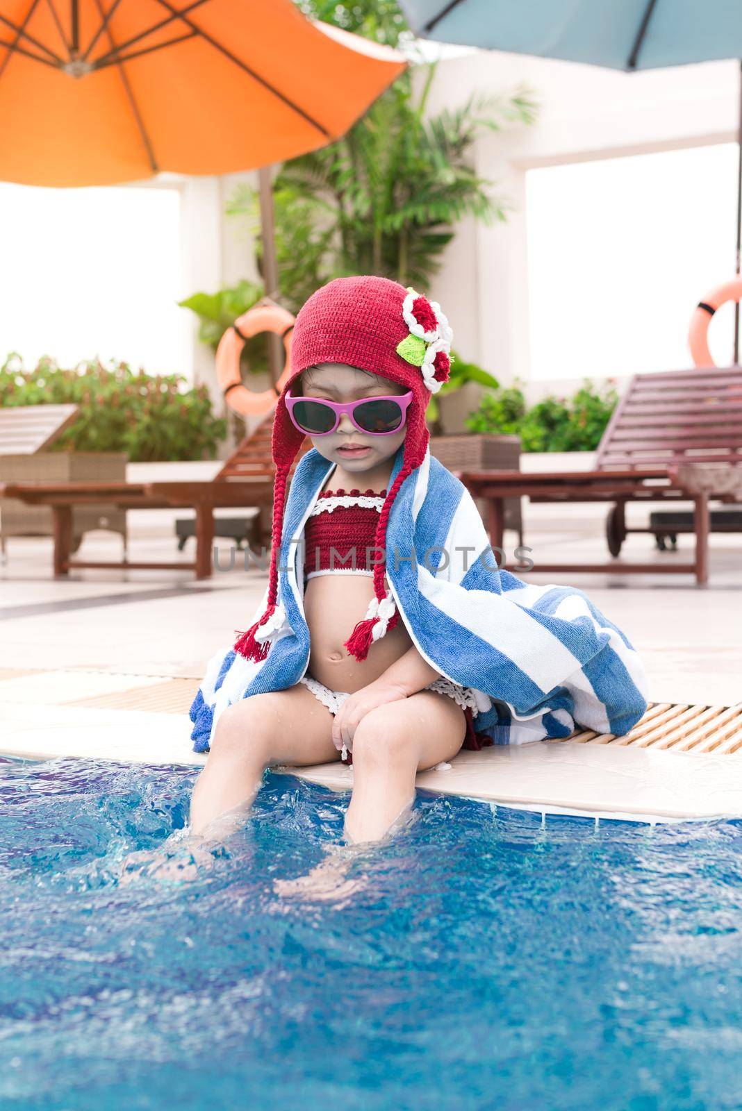 Little girl having fun in the pool. Summer holidays and vacation concept