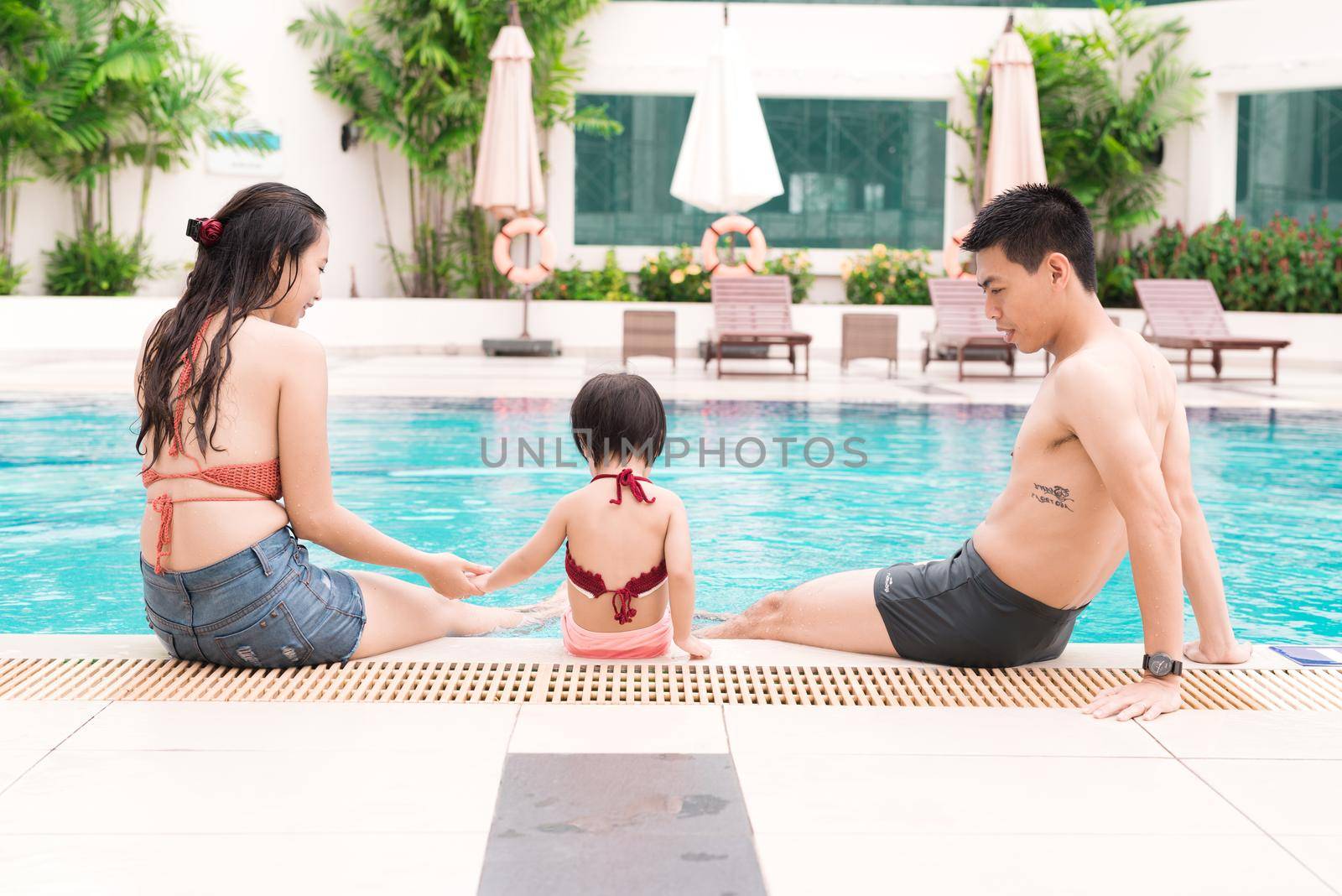 Happy family in swimming pool. Summer holidays and vacation concept