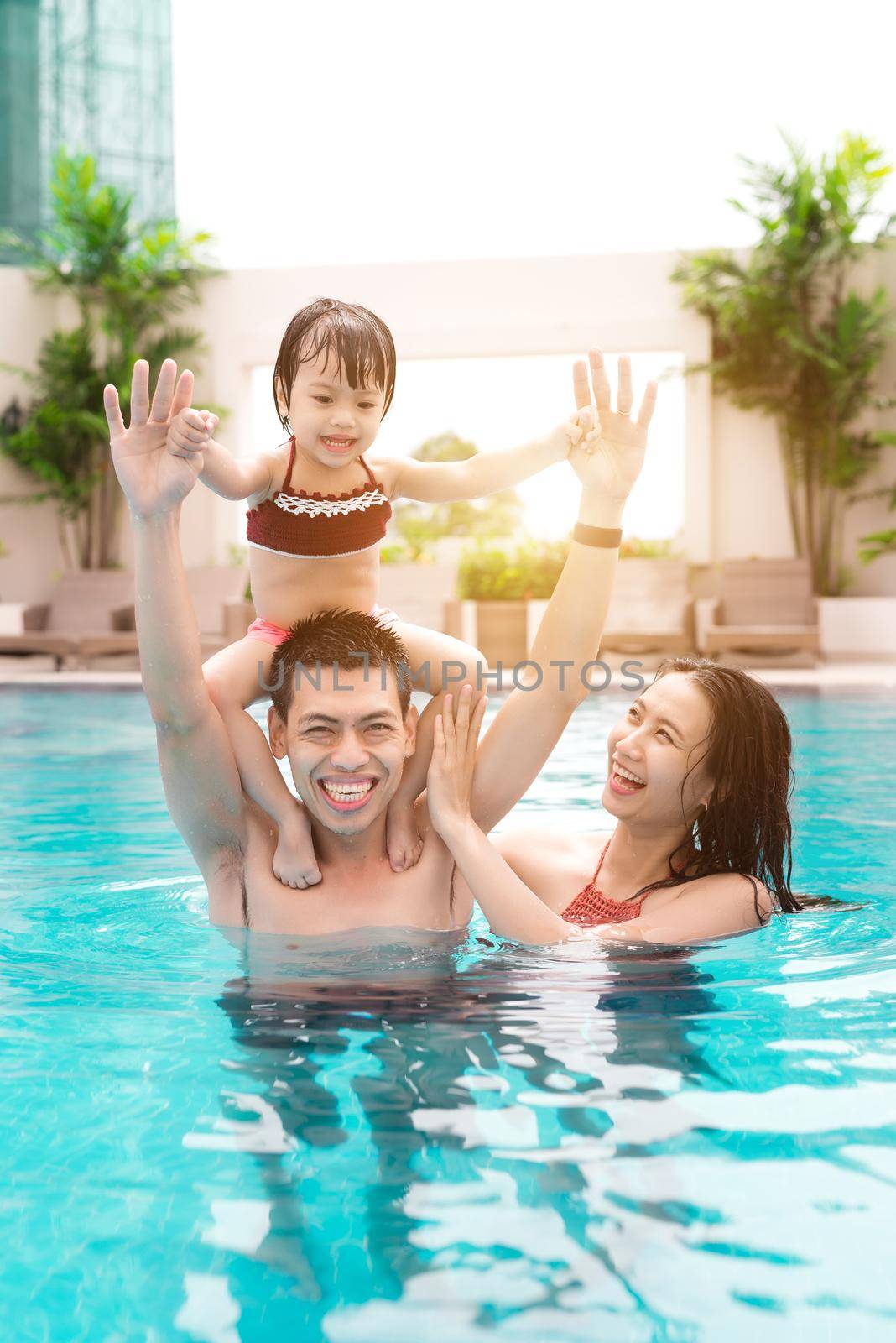 Happy family in swimming pool. Summer holidays and vacation concept by makidotvn