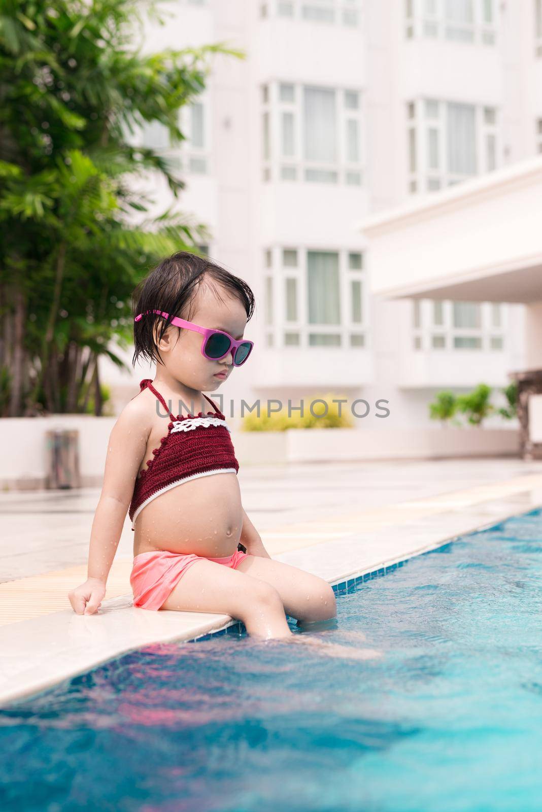 Little girl having fun in the pool. Summer holidays and vacation concept by makidotvn