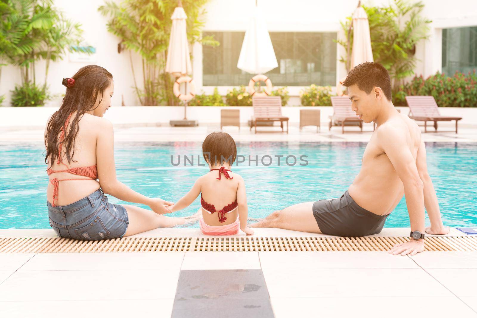 Happy family in swimming pool. Summer holidays and vacation concept