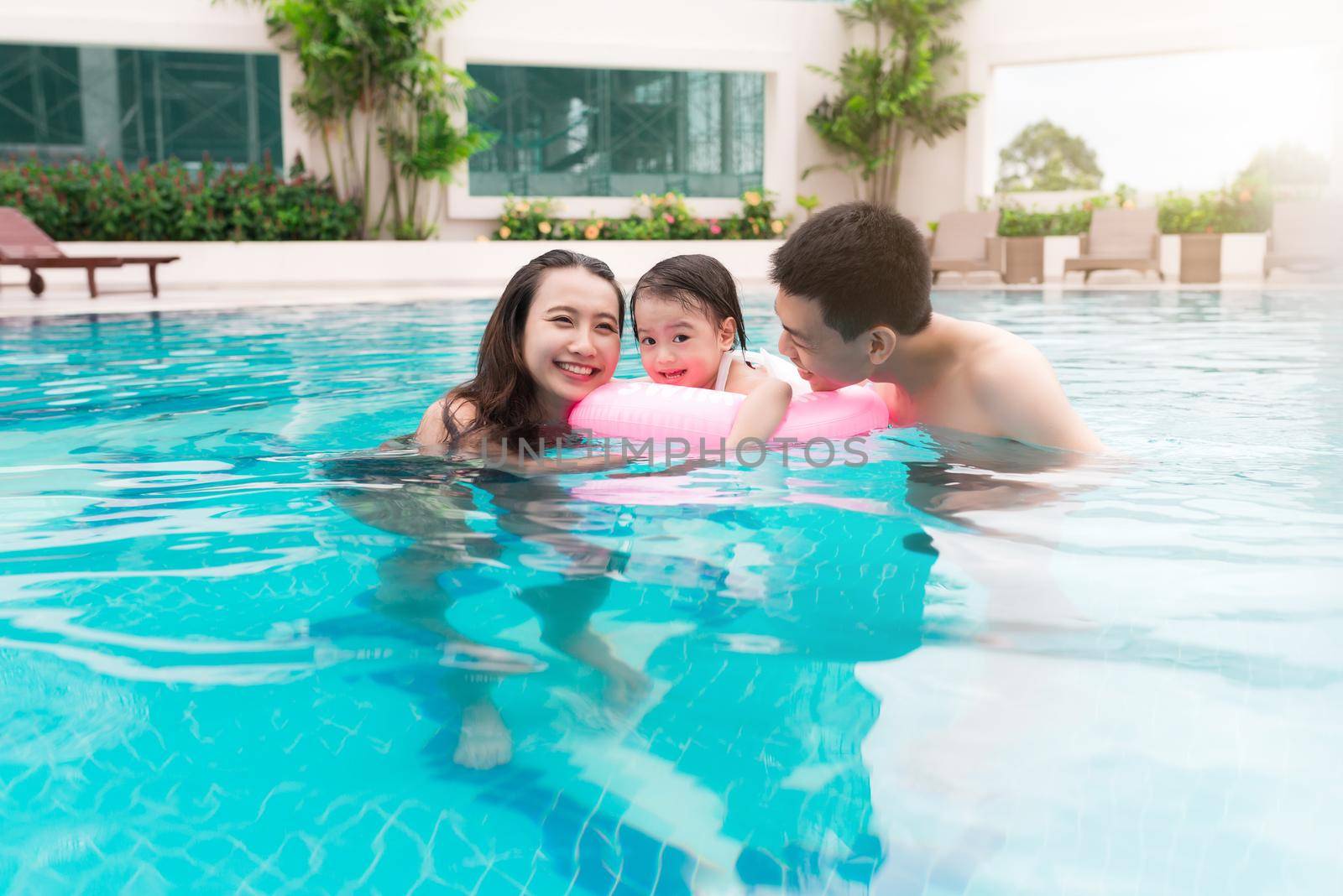 Happy family in swimming pool. Summer holidays and vacation concept