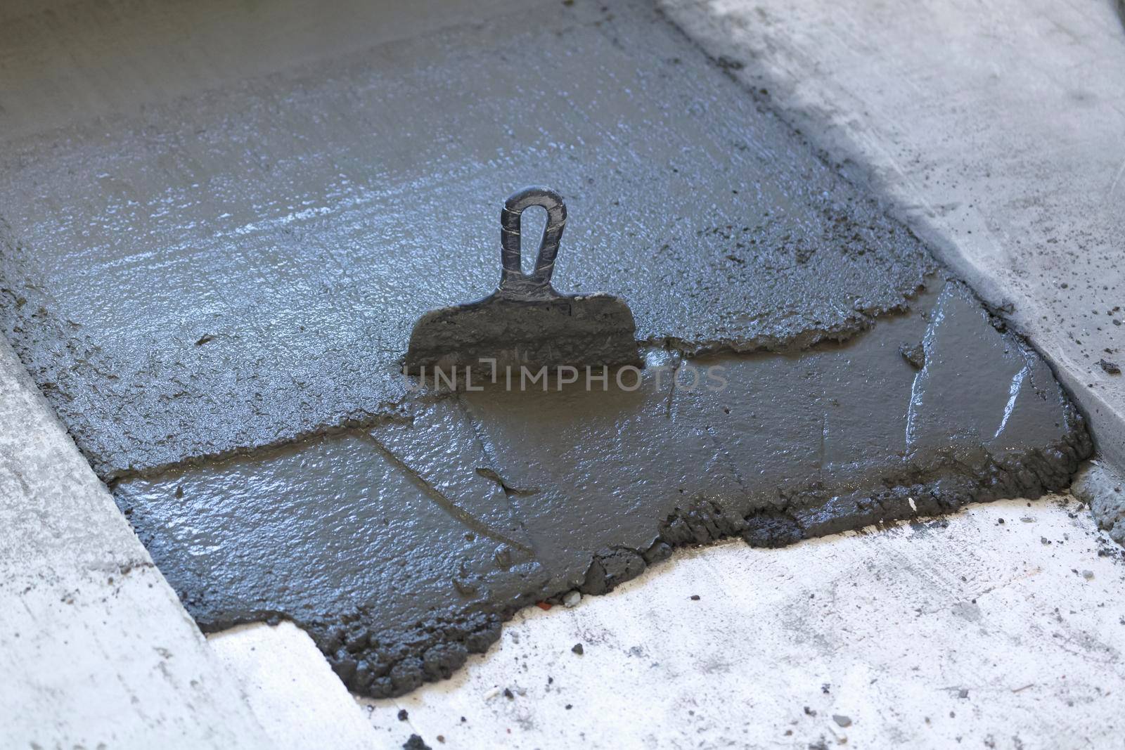 trowel in a layer of fresh concrete on the floor