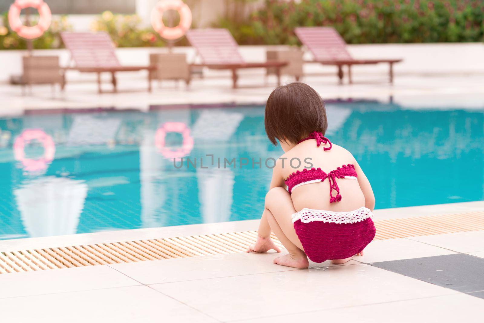 Little girl having fun in the pool. Summer holidays and vacation concept