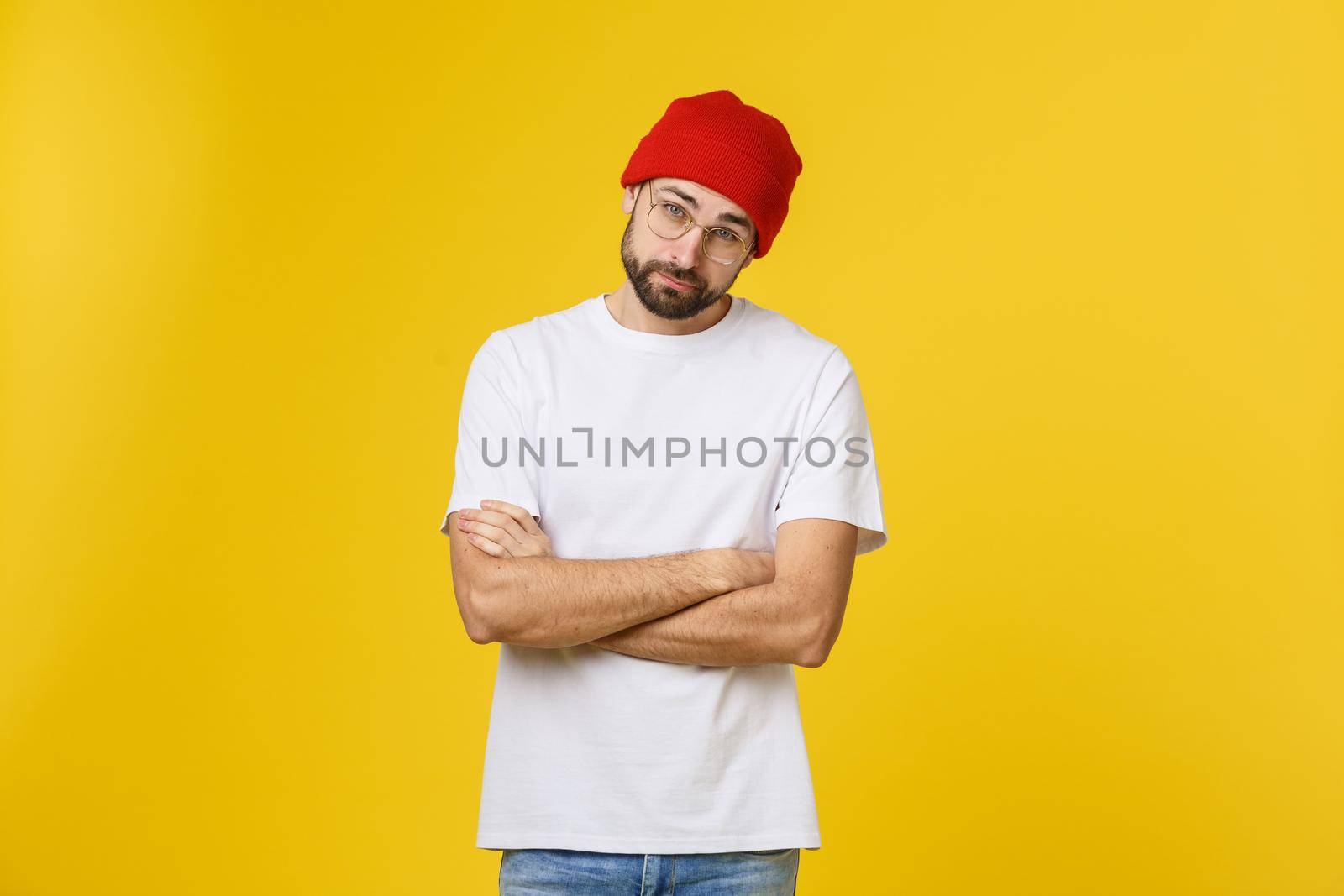 Portrait unhappy handsome man looking at camera on yellow background