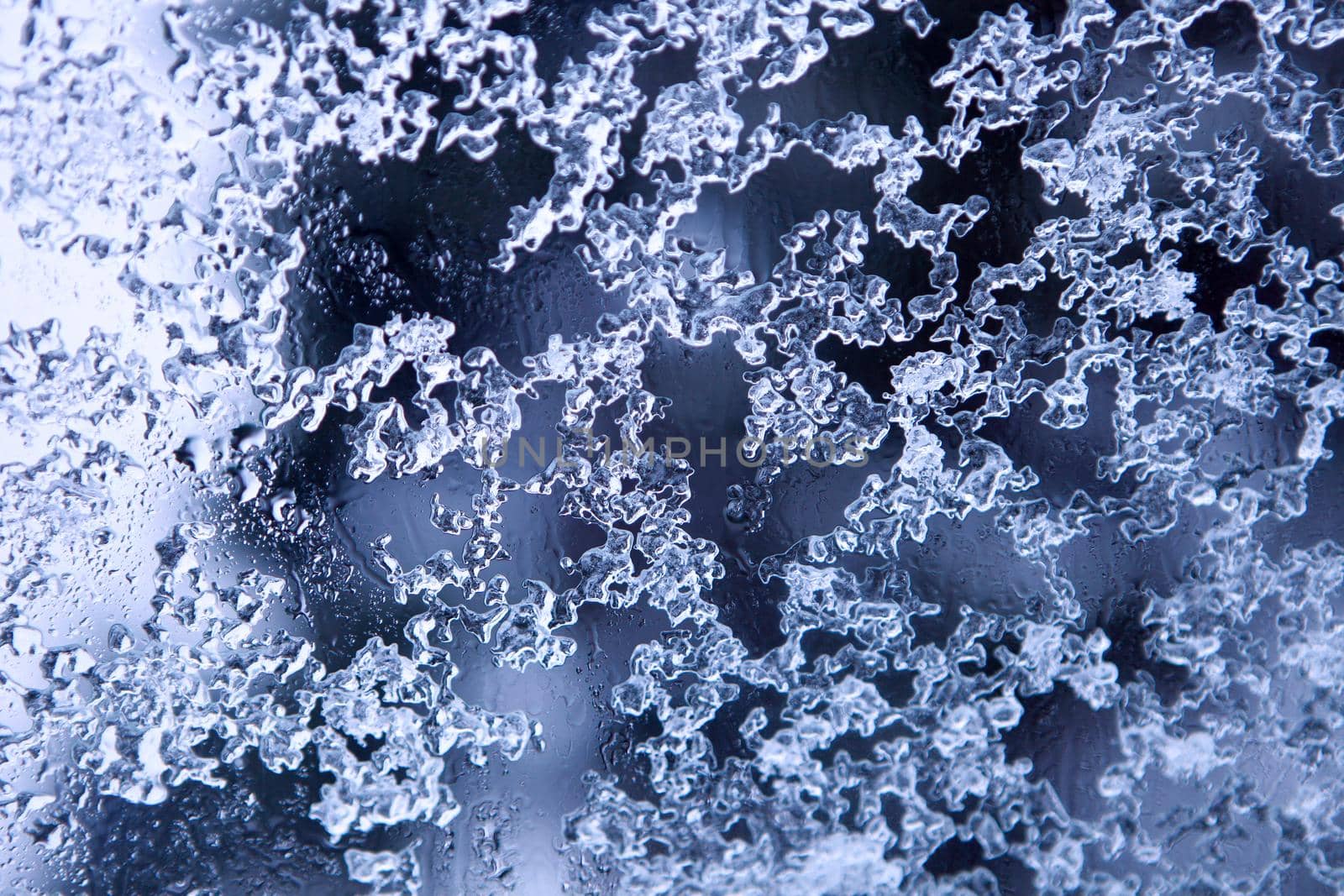 Frozen decorative water drops - natural winter ice pattern on glass. melting snowflakes by julija