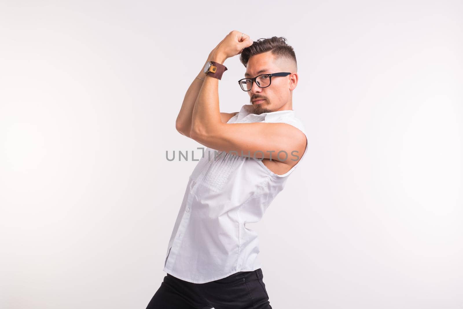 People, clothing and style concept - young handsome man posing in white shirt on white background.