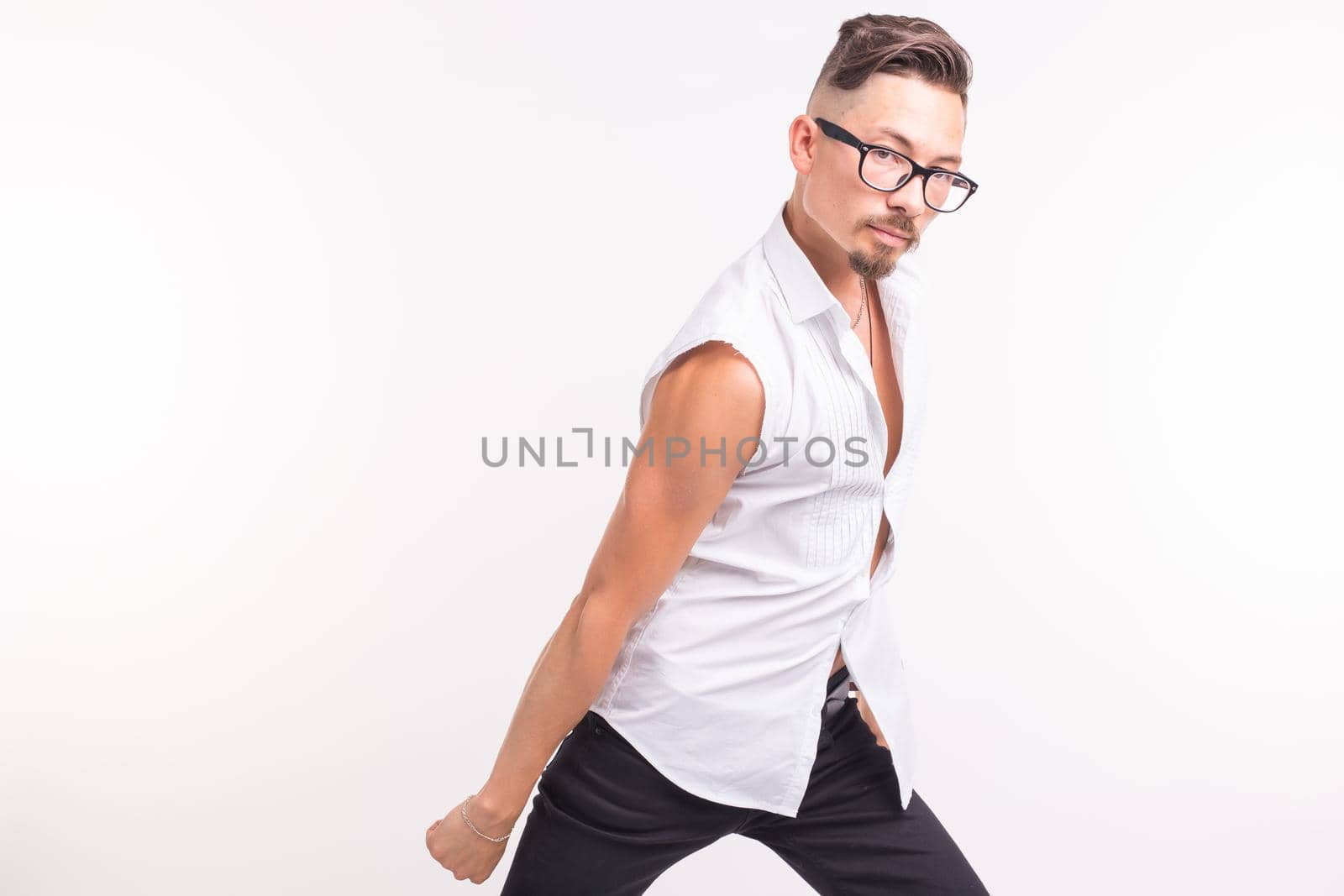 People, clothing and style concept - young handsome man posing in white shirt on white background.