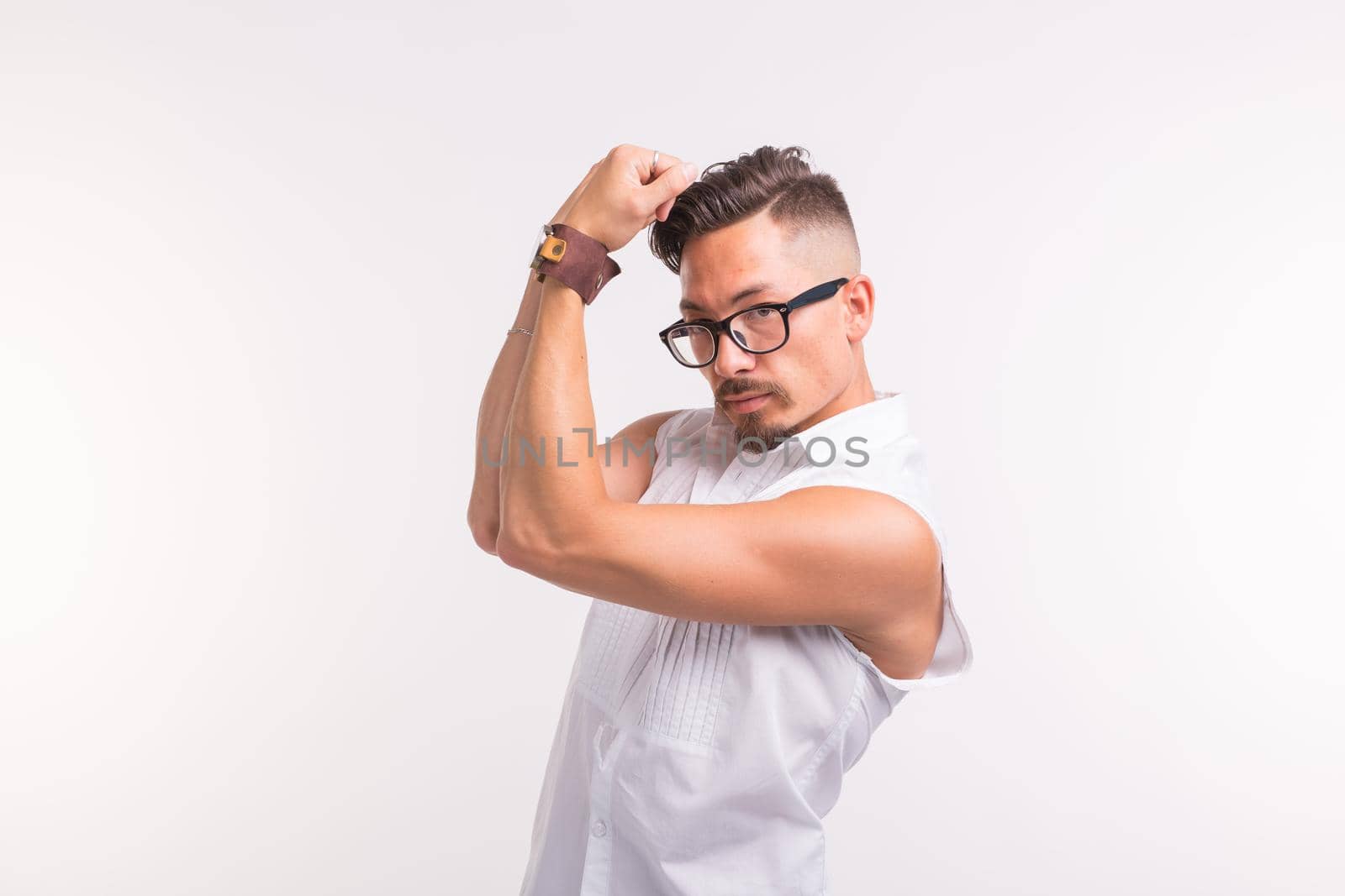 People, clothing and style concept - young handsome man posing in white shirt on white background.