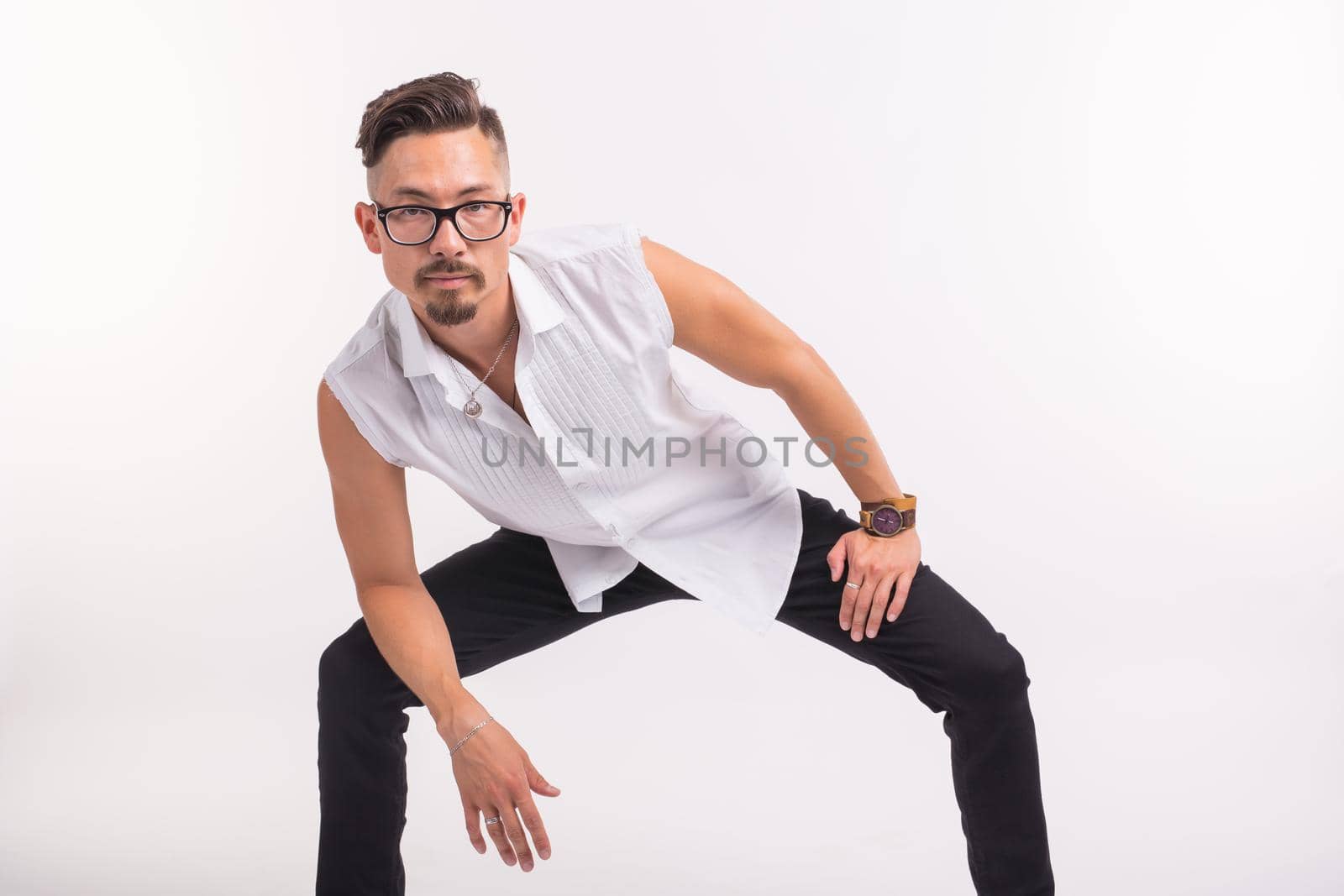 People, clothing and style concept - young handsome man posing in white shirt on white background.