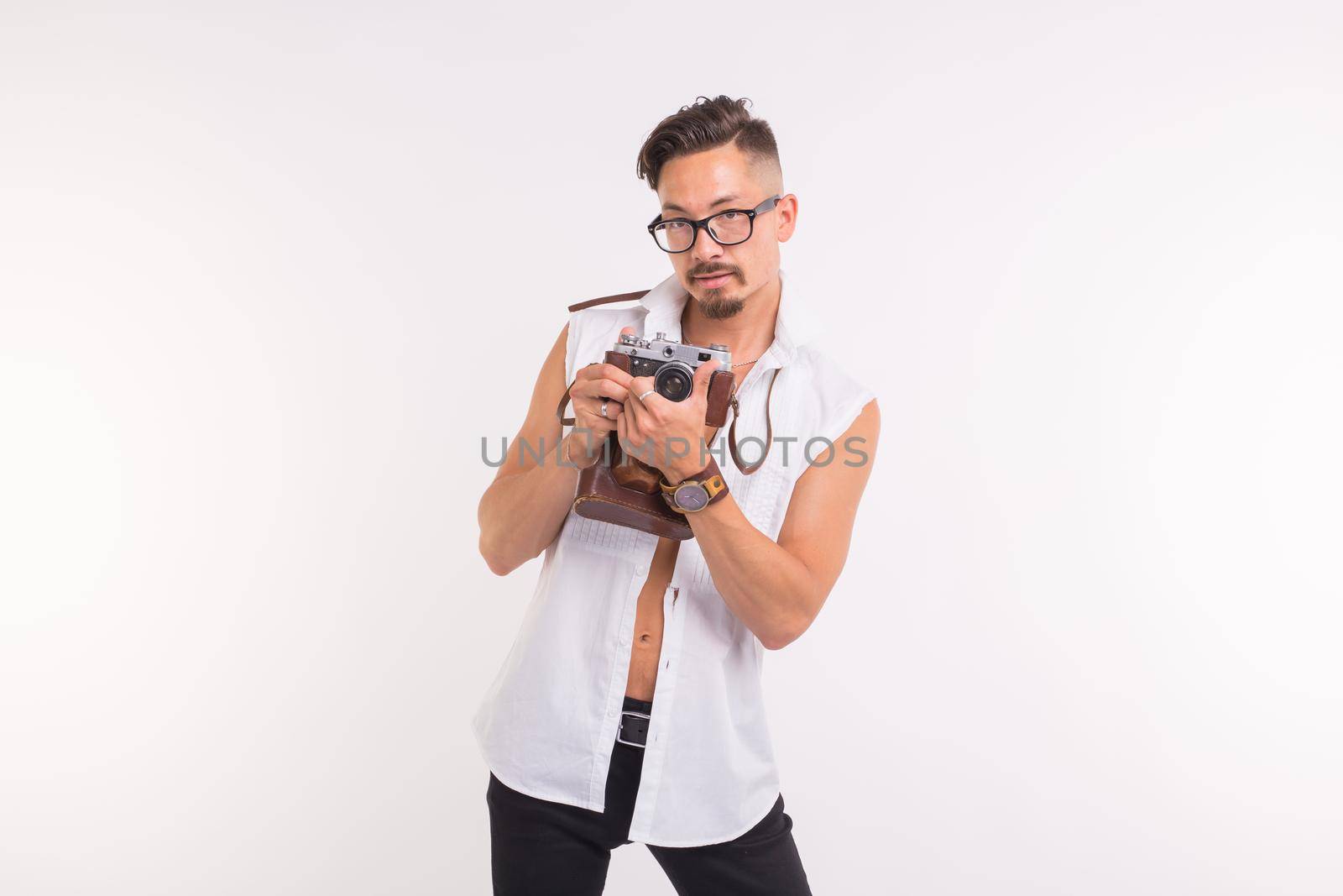 Technologies, photographing and people concept - handsome young man with retro camera over white background.