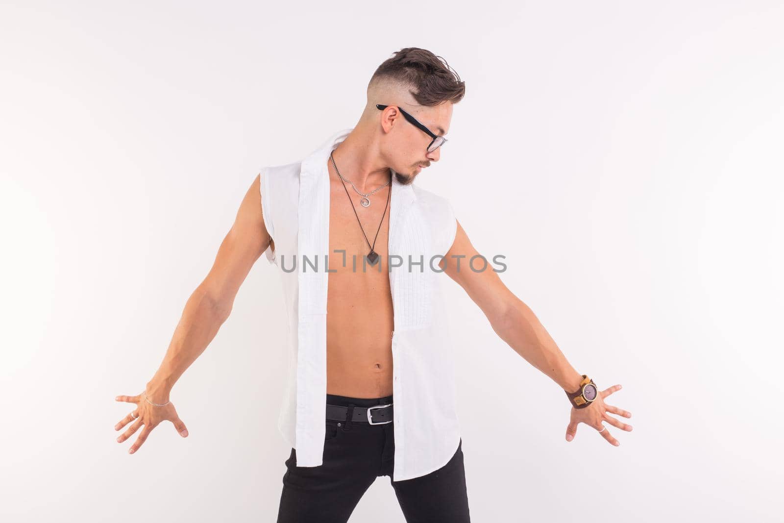 People, clothing and style concept - young handsome man posing in white shirt on white background.