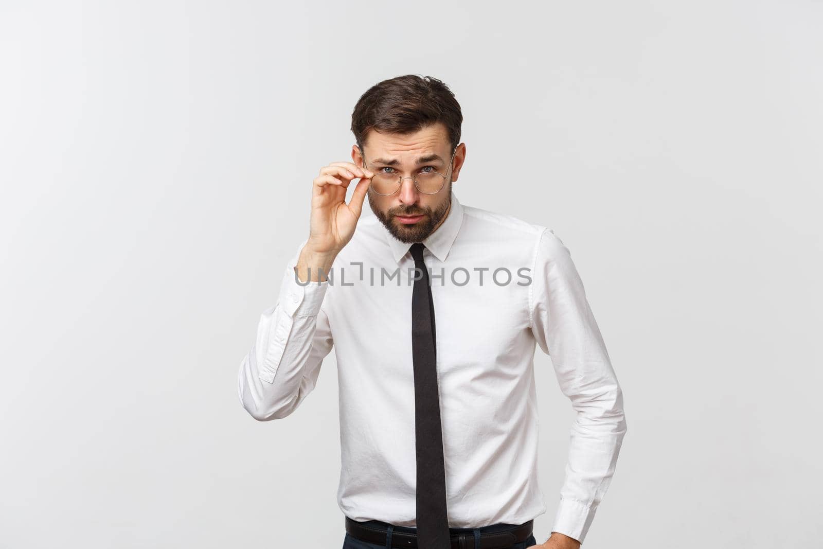 Closeup portrait of handsome young businessman in glasses, looking at camera