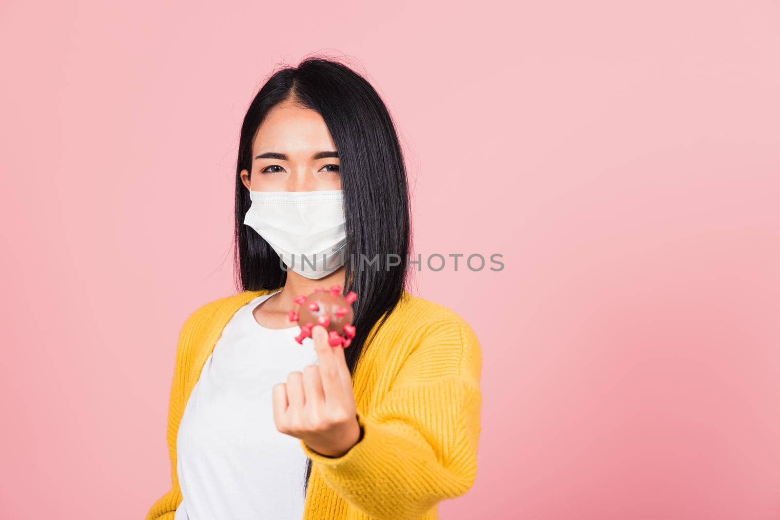 Portrait of Asian young woman wear face mask protective holding DNA strand of Coronavirus (COVID-19, 2019-ncov) genetic instruction, new strain RNA mutation, studio shot isolated on pink background