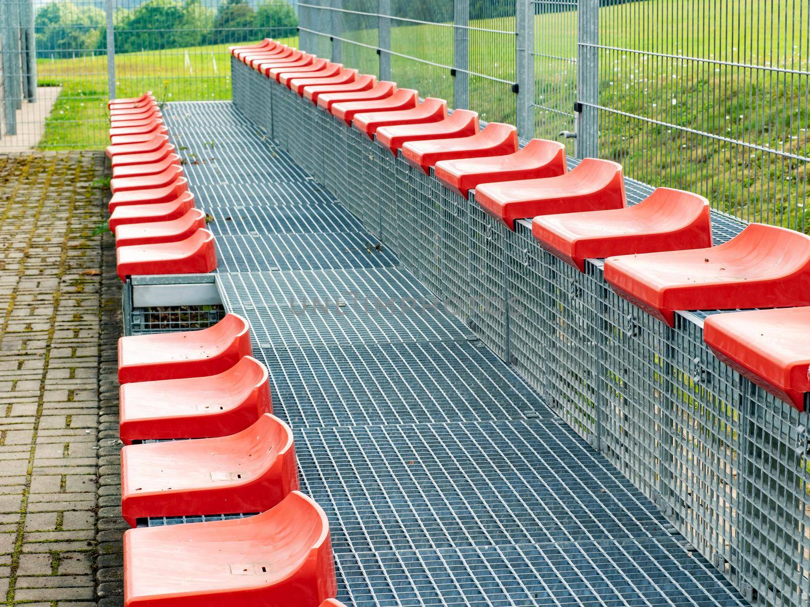 Red tribune chairs. Plastic stadium seats  by rdonar2