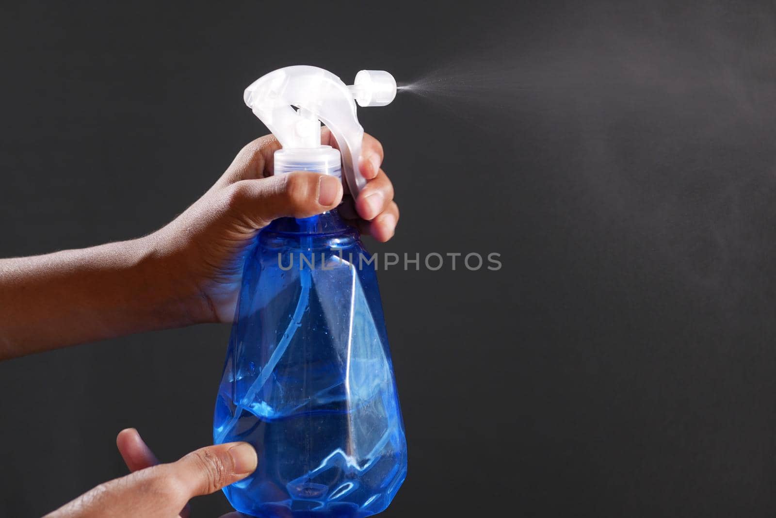 hand in blue rubber gloves holding spray bottle with copy space, top view