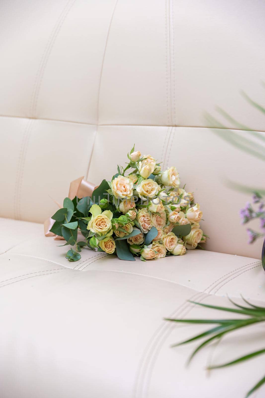A bouquet of beautiful flowers lies on the sofa. High quality photo