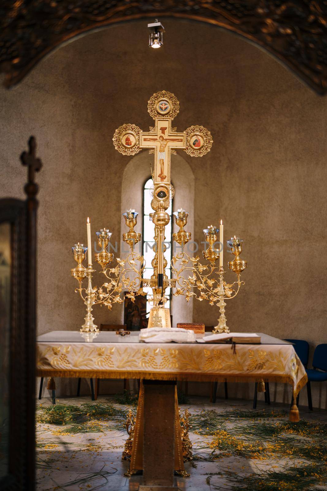 Branched gold candlestick on a table in front of a cross in the Church of St. Sava in Tivat. High quality photo