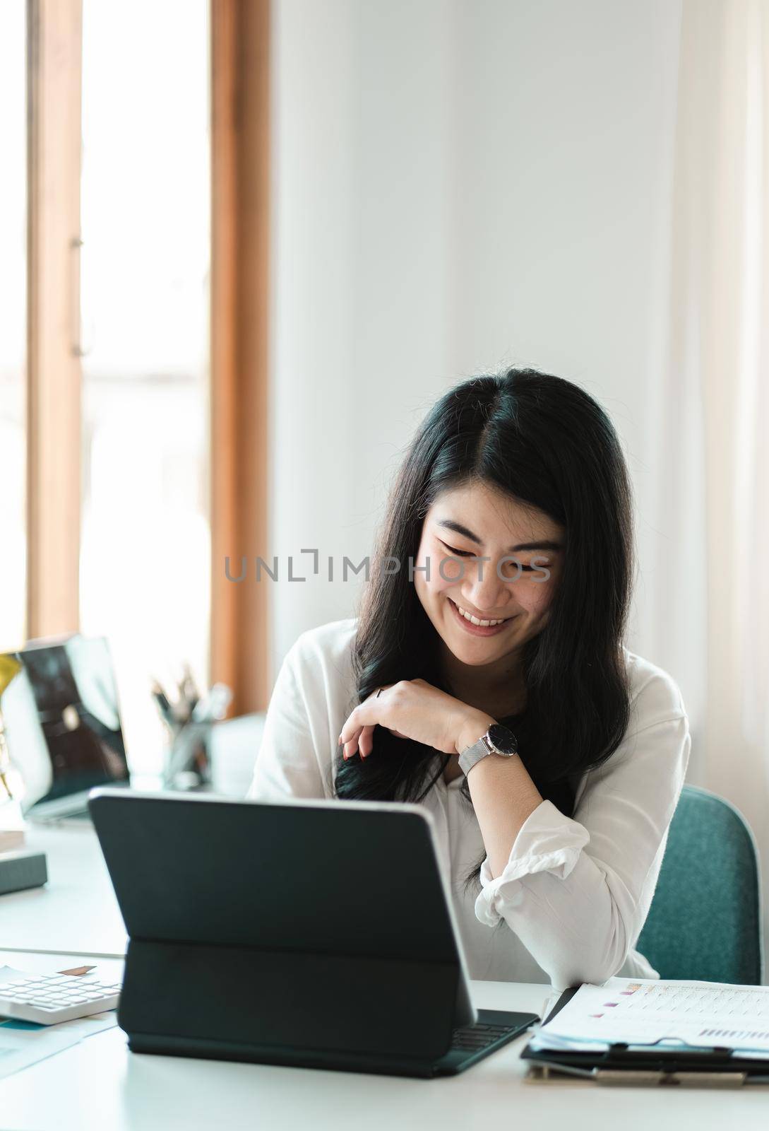 Portrait of Happy Young attractive business woman using digital laptop computer. do math finance on wooden desk, tax, accounting, report statistics and analytical research technology concept.