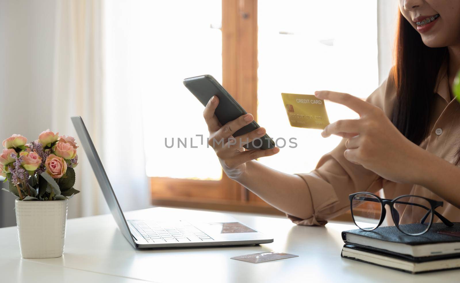 Happy woman using mobile app to online shopping and pay whit credit card at home.