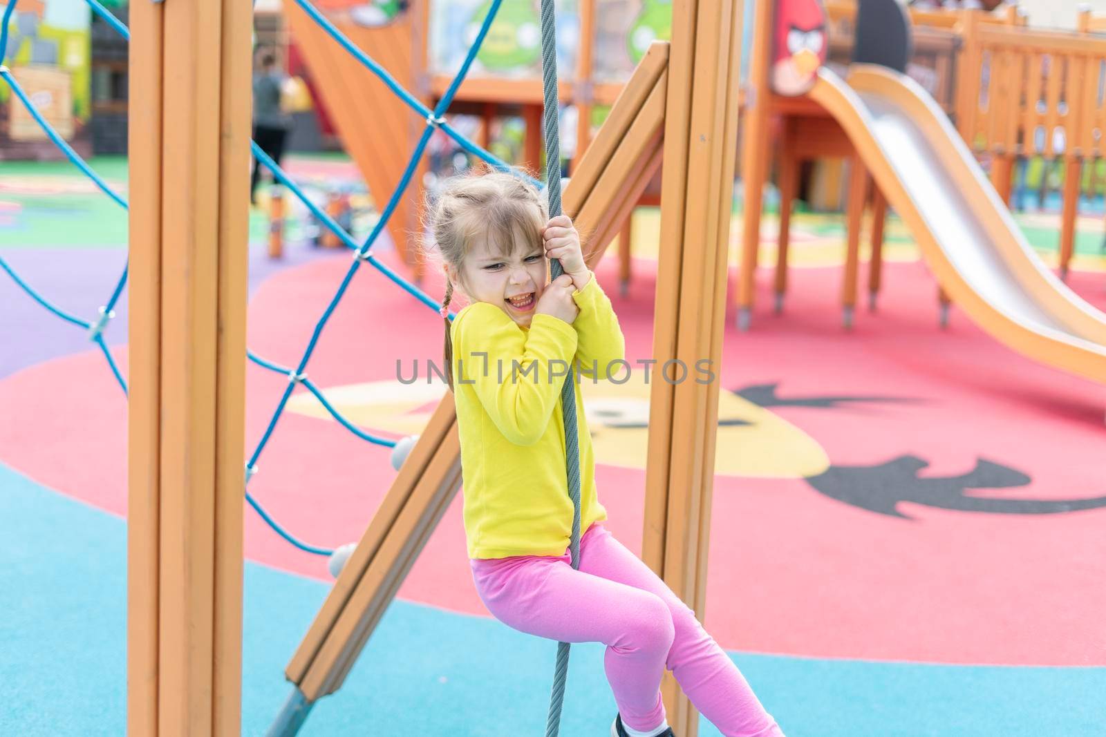 cute kid girl playing and climbing on the playground