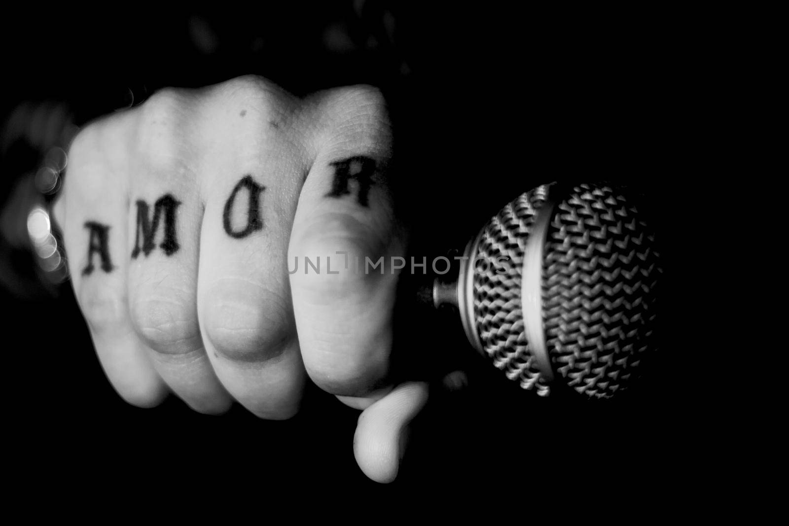 Singer man with round microphone on dark background. Copy space