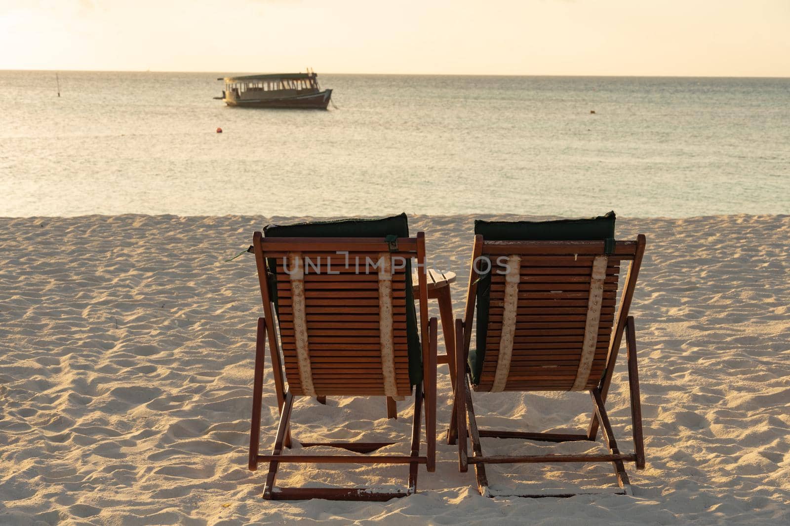 Close-up of sunbeds set on a beautiful tropical beach. Impressive image for every use. by silentstock639