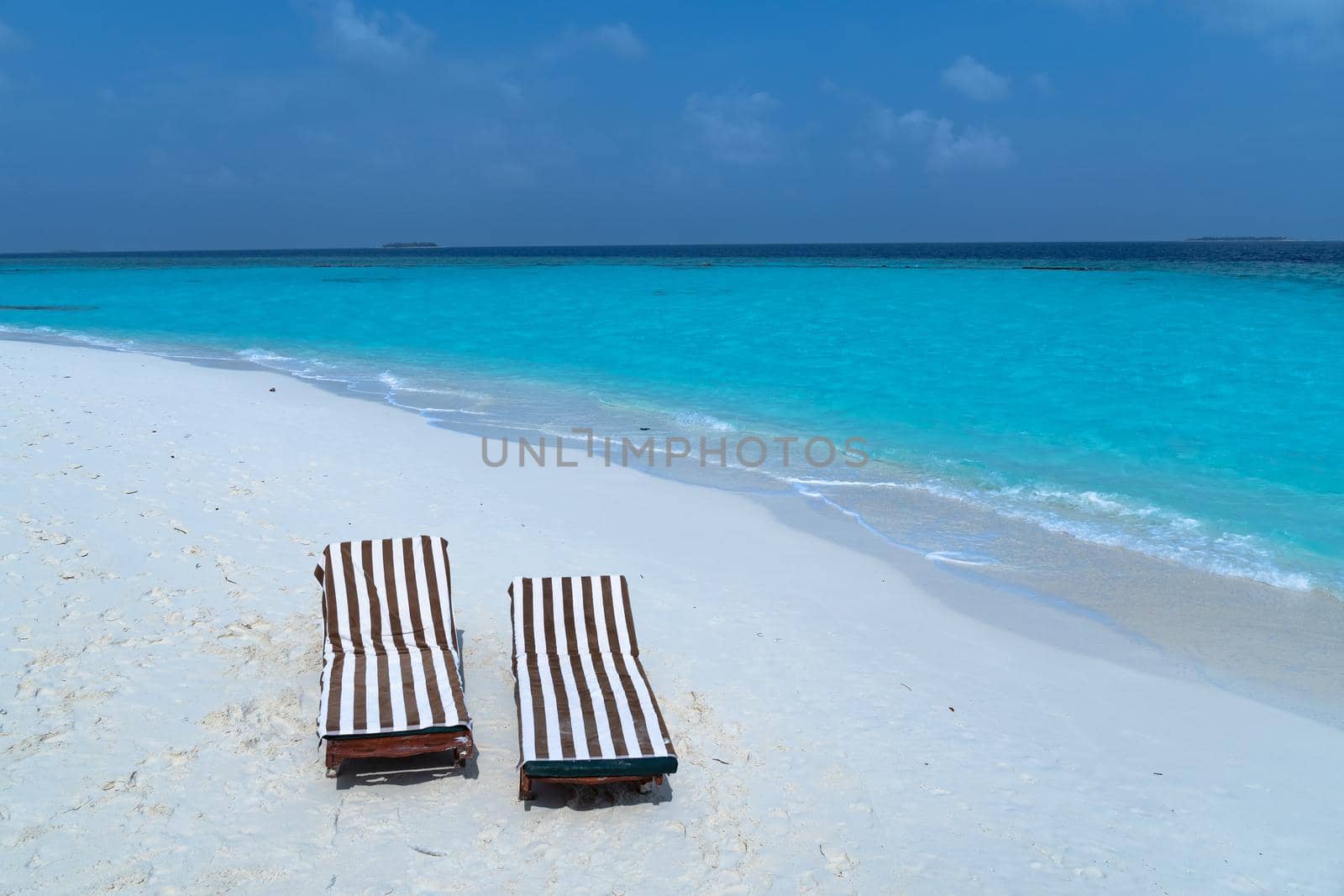 Close-up of sunbeds set on a beautiful tropical beach. Impressive image for every use. by silentstock639