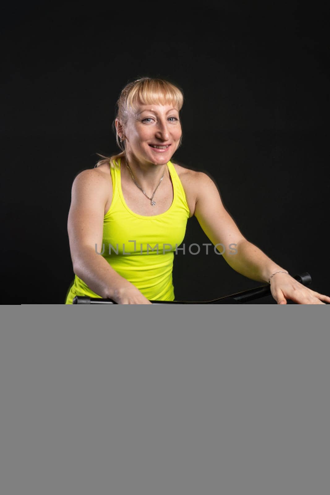 Girl on a fitness trampoline on a black background in a yellow t-shirt yellow equipment fitness healthy cardio, weight rebounder. Fly mini motion, elastic muscle instructor enjoy by 89167702191