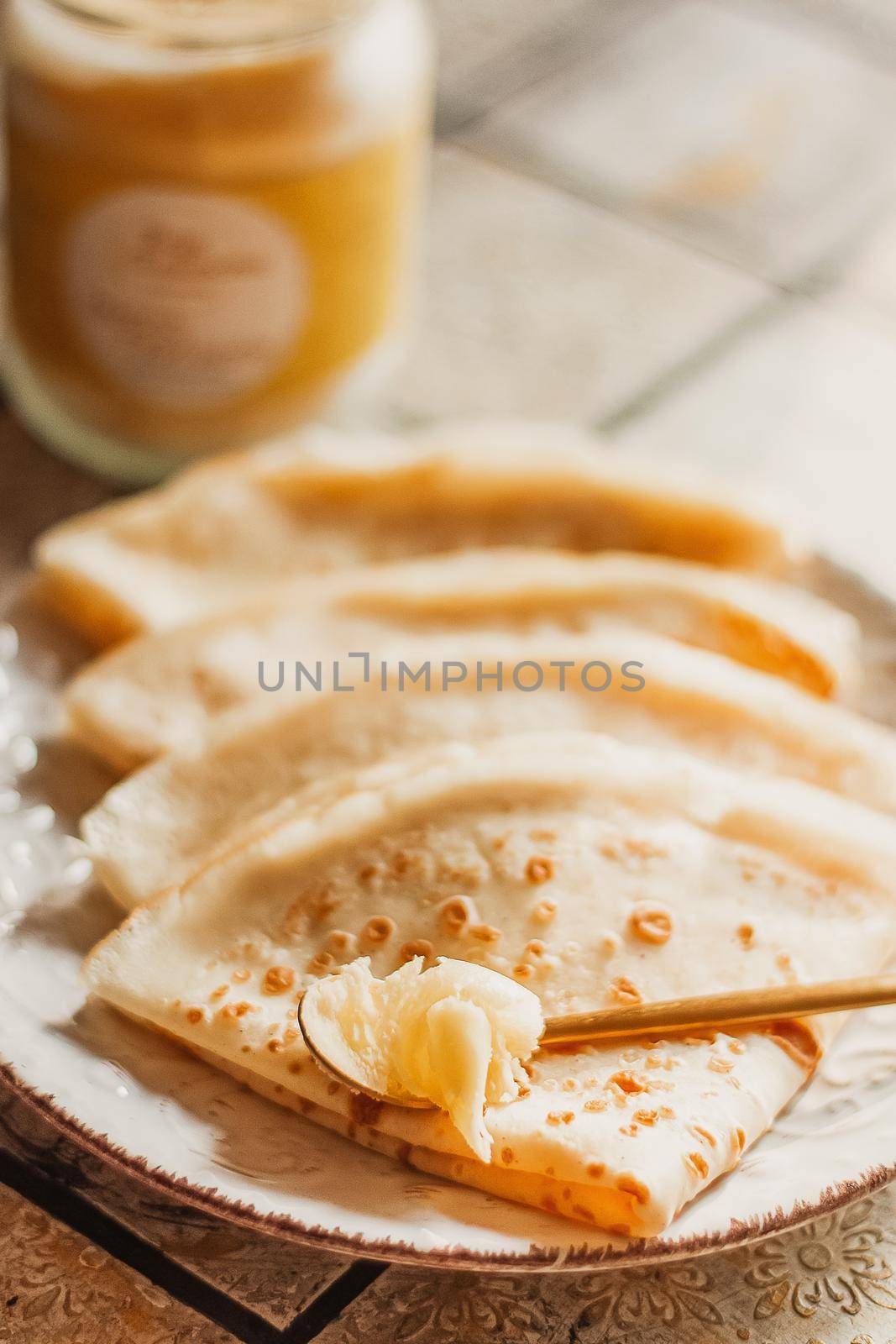 Ghee butter in glass jar and pancakes on table. Healthy eating, breakfast.