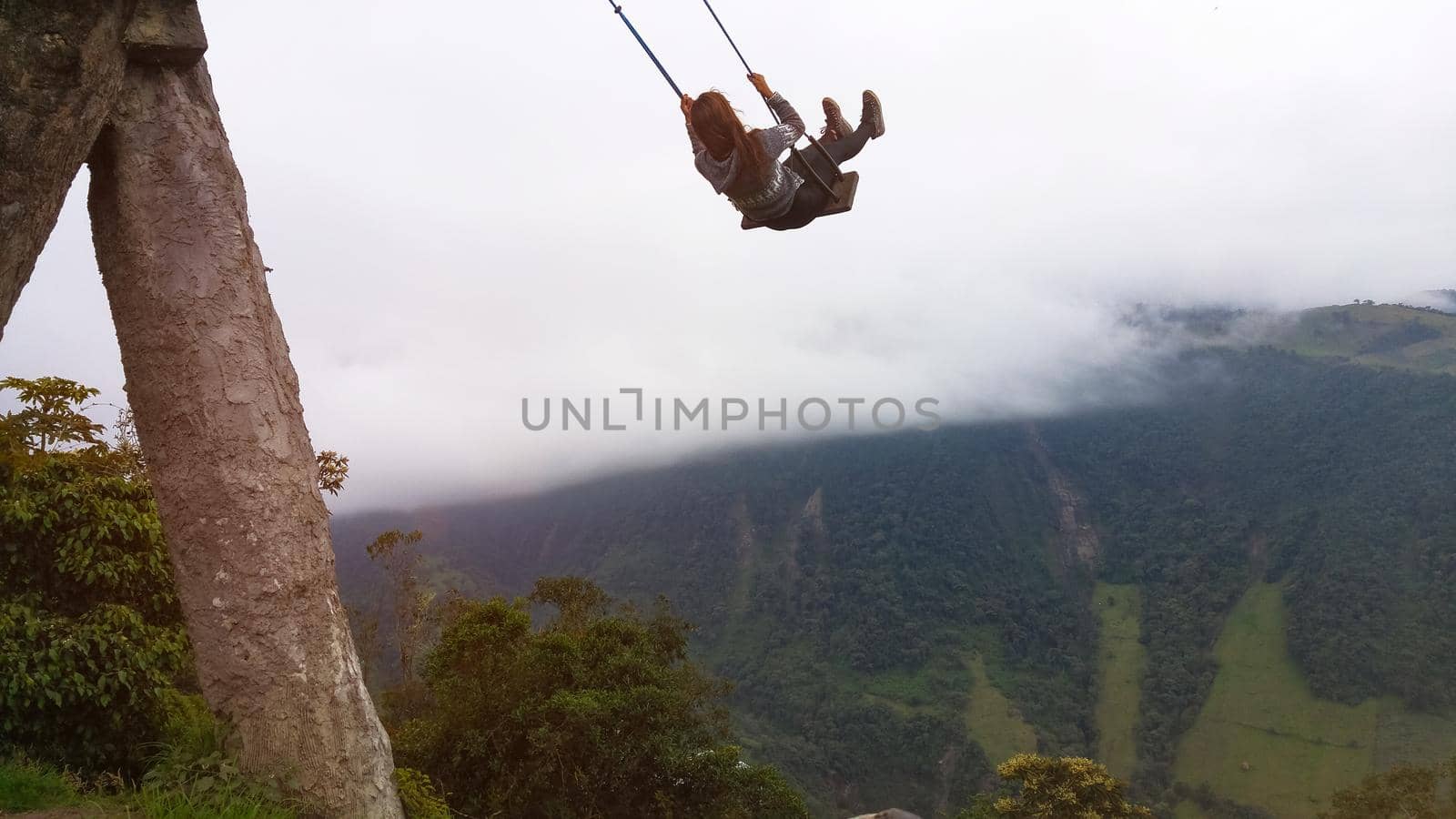 Woman enjoying the End of the World swing up the mountains at La Casa del arbol, Banos, Ecuador