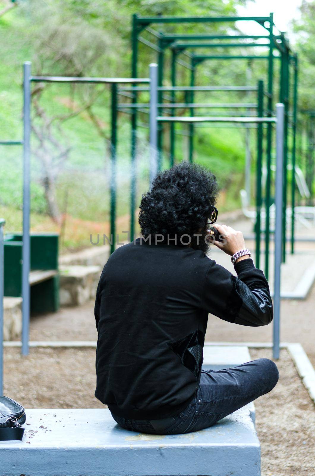 Man with beard smoking electronic sigarette outdoor. by Peruphotoart