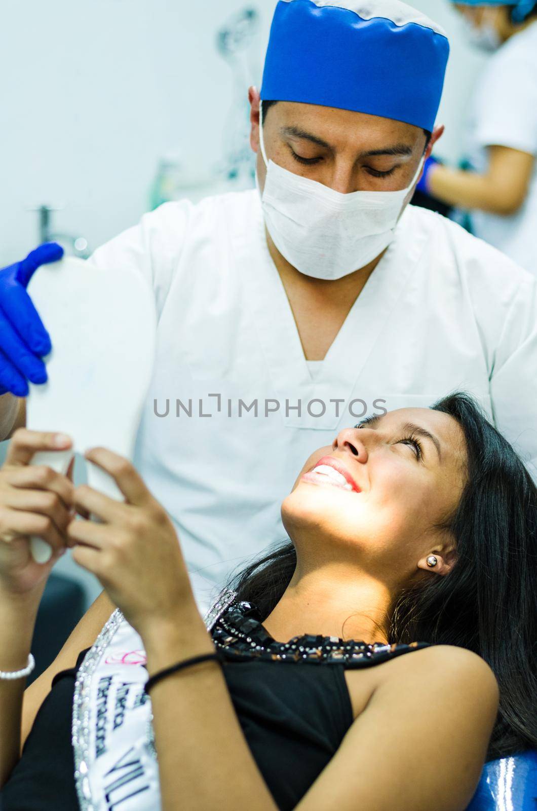 Smiling patient while dentist examining it. Dental photo series